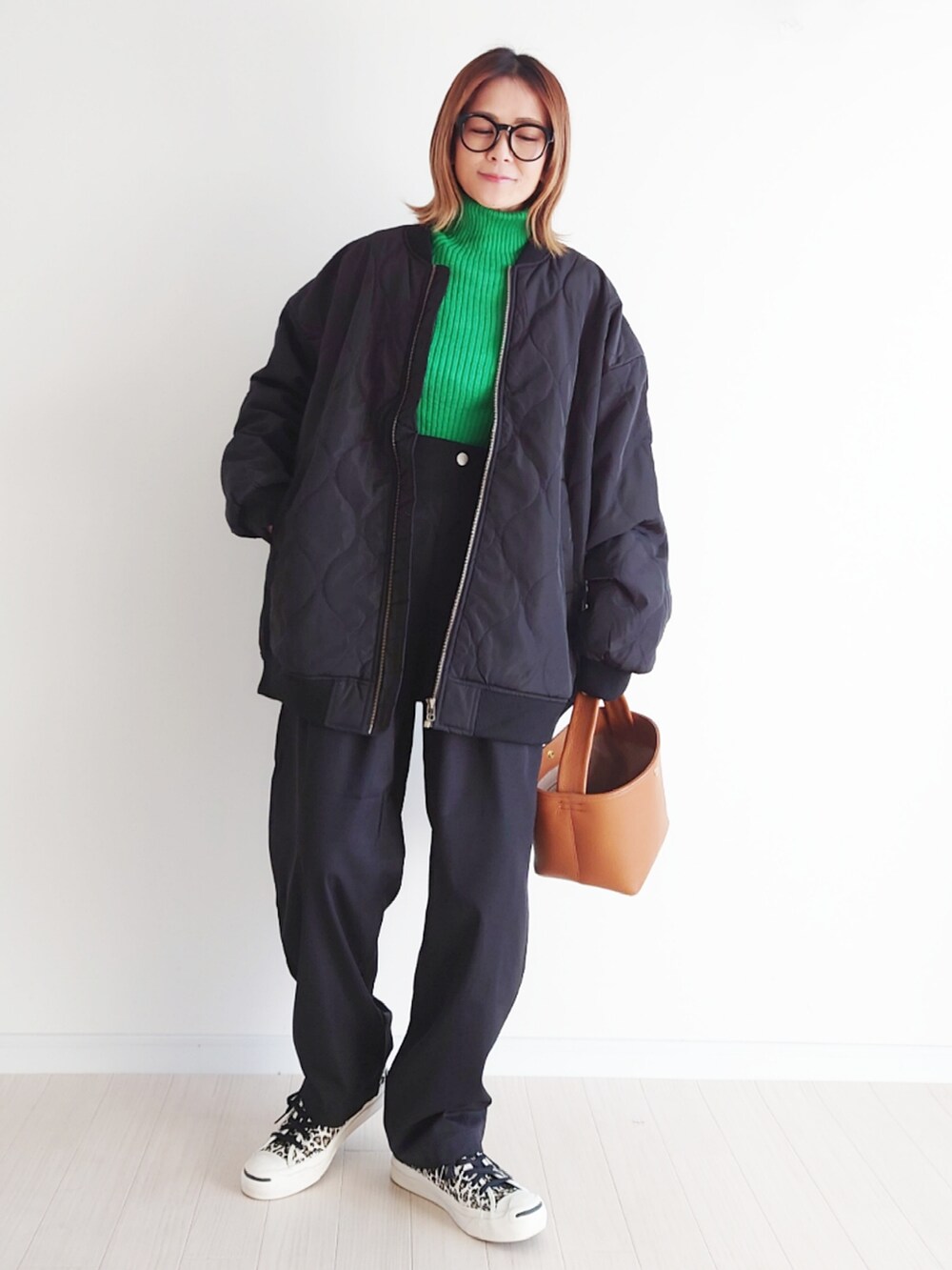 ブラック系のブルゾン、ブラック系のスラックス、グリーン系のニット/セーターを着用したレディースの冬コーディネートの2枚目の写真