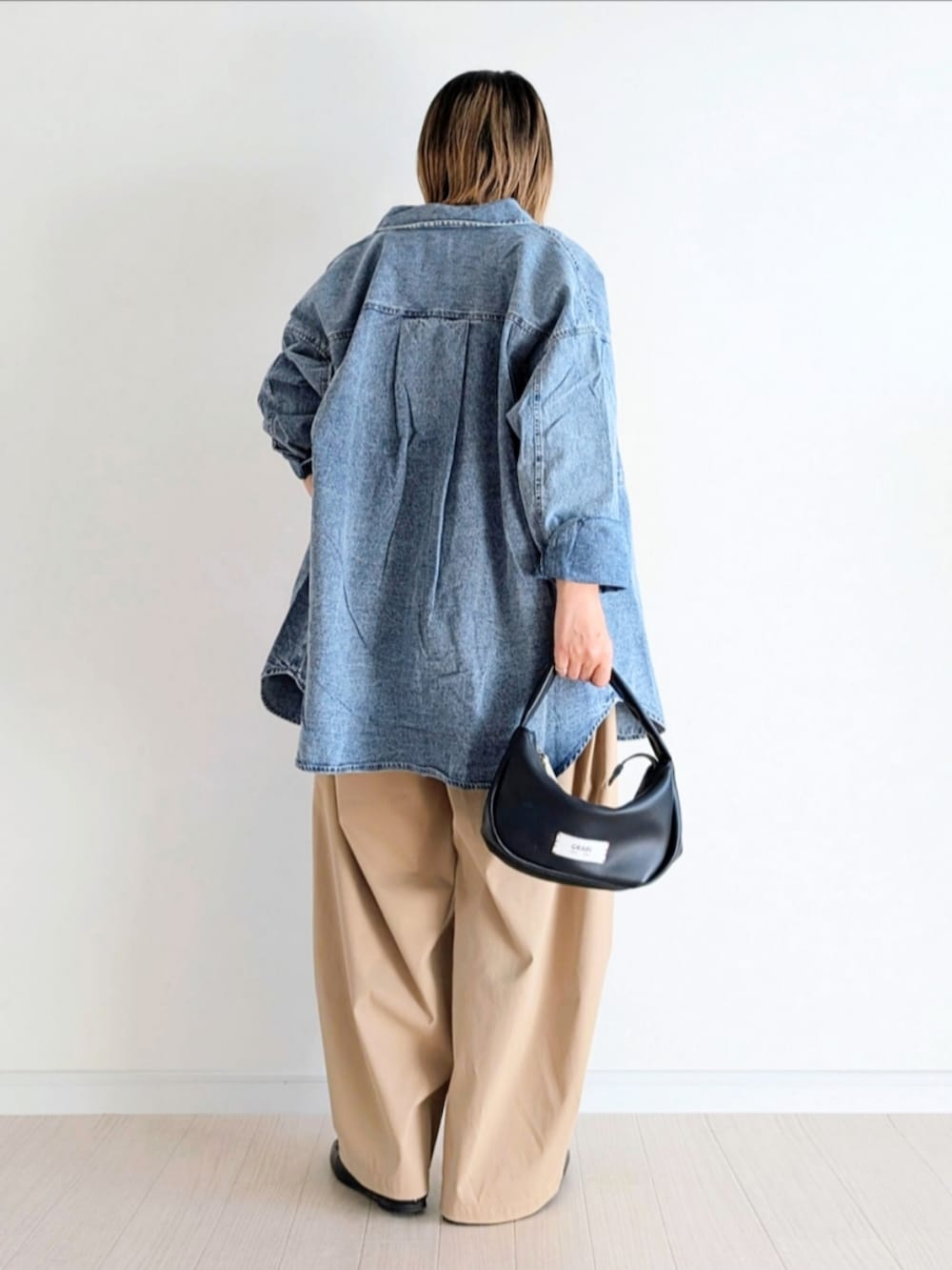 ベージュ系のチノパンツ、ブルー系のシャツ/ブラウス、ホワイト系のTシャツ/カットソーを着用したレディースの春コーディネートの3枚目の写真