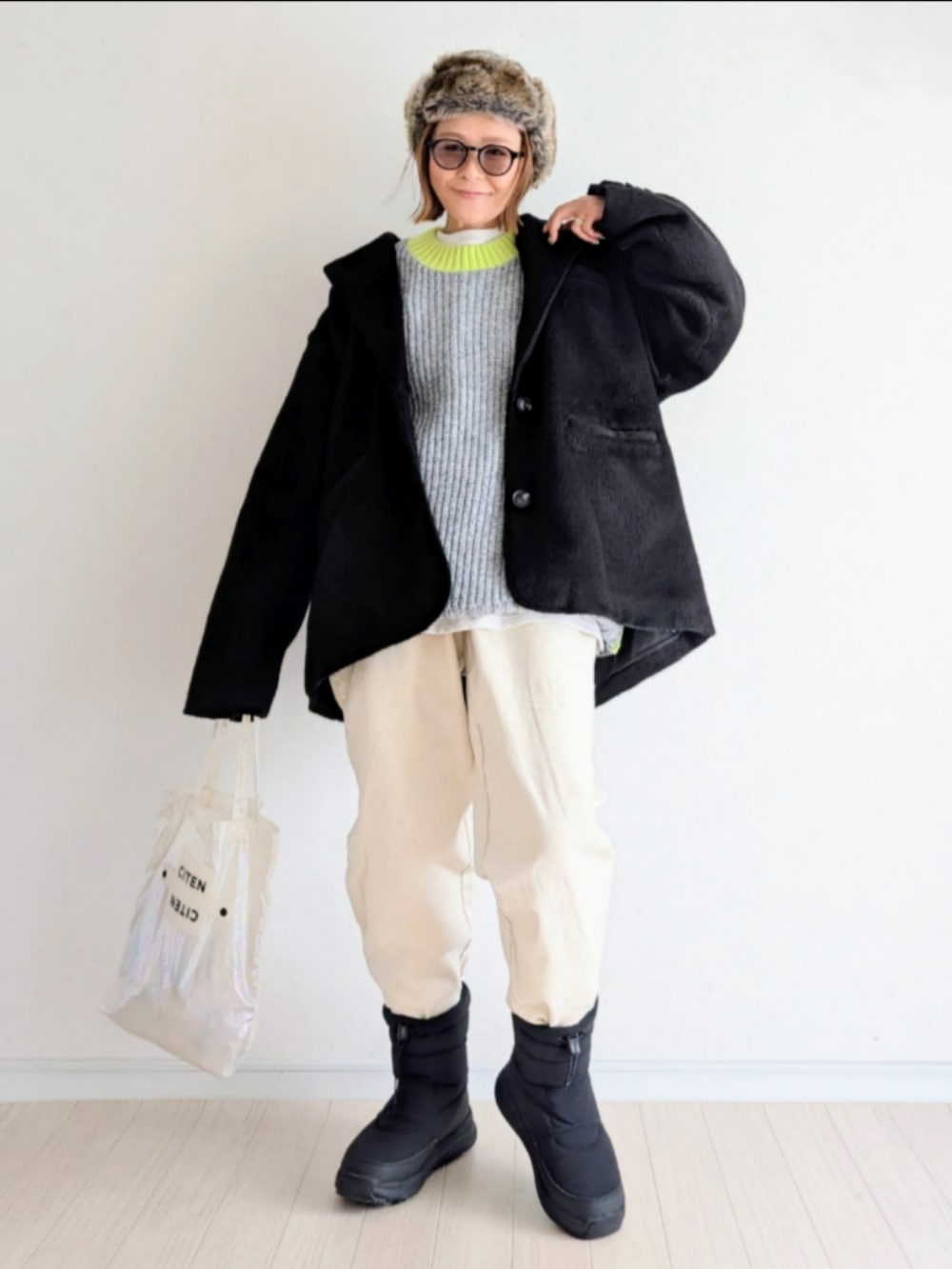 グレー系のニット/セーター、ブラック系のテーラードジャケット、ブラック系のブーツを着用したレディースの冬コーディネートの2枚目の写真