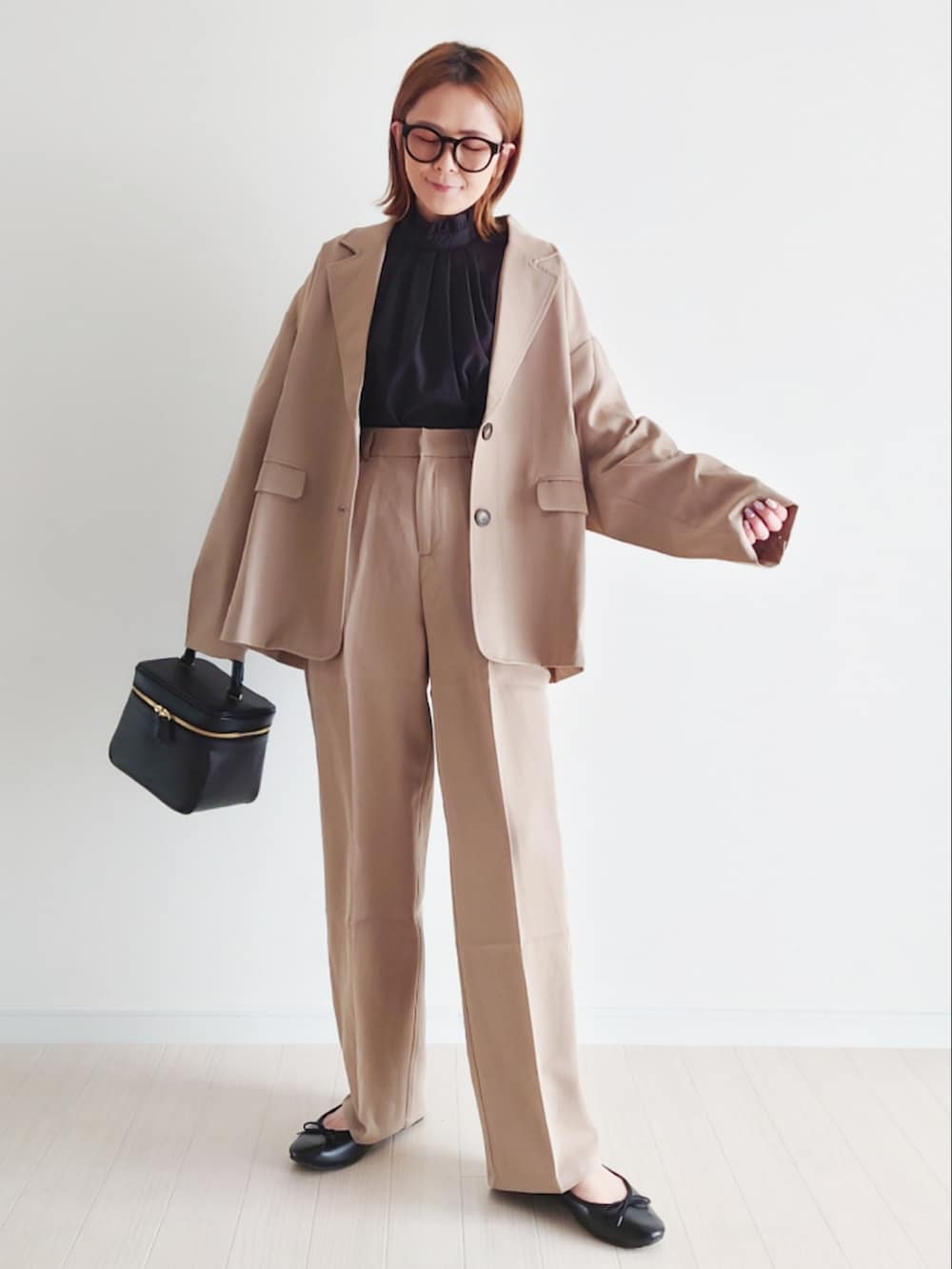 ベージュ系のセットアップ、ブラック系のシャツ/ブラウス、ブラック系のハンドバッグを着用したレディースの冬コーディネートの2枚目の写真