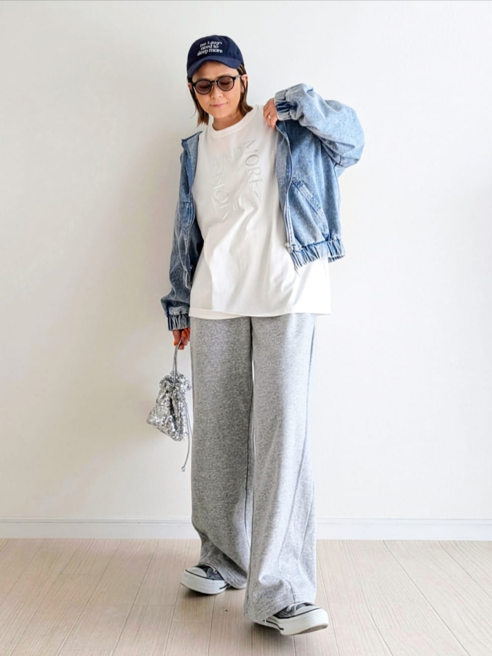 ブルー系のデニムジャケット、ホワイト系のTシャツ/カットソー、グレー系のスウェットパンツを着用したレディースの春コーディネートの4枚目の写真