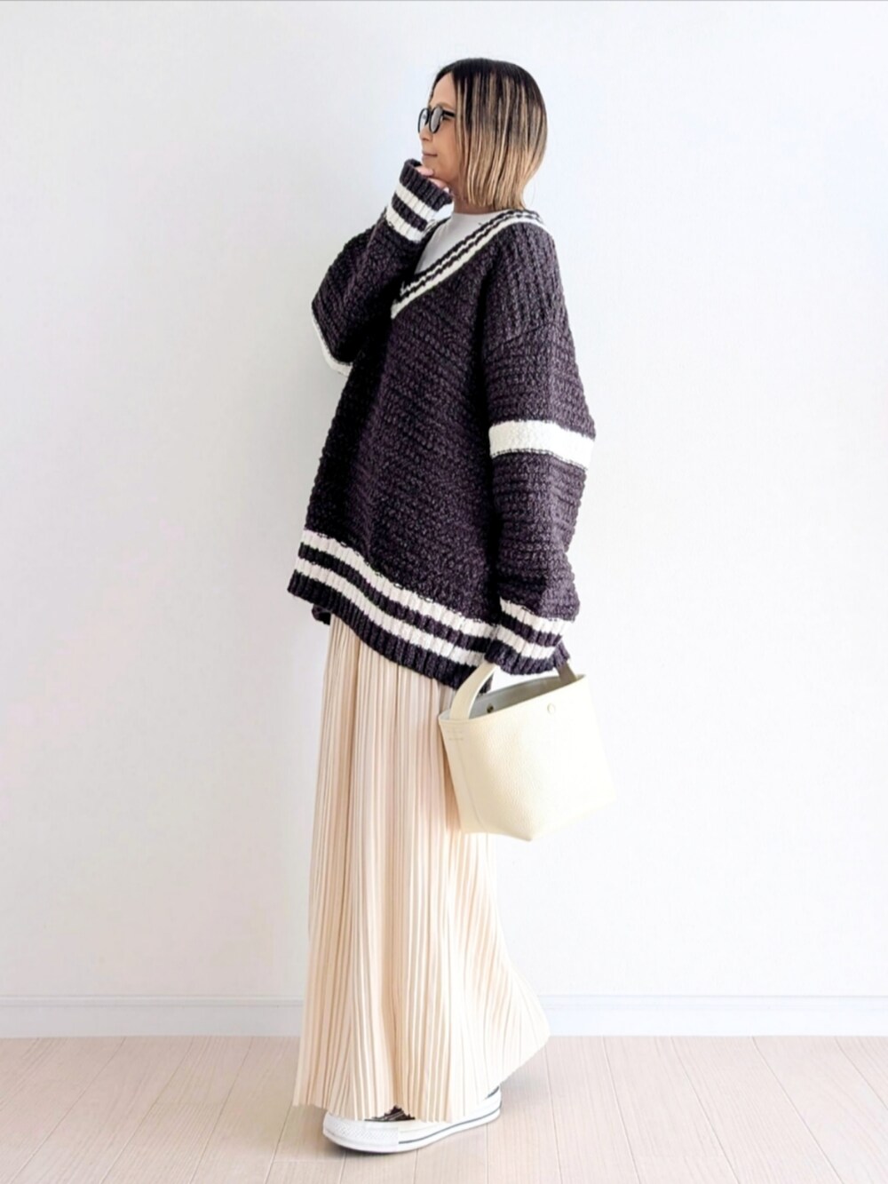 ホワイト系のスカート、グレー系のニット/セーター、その他のシューズを着用したレディースの冬コーディネートの3枚目の写真