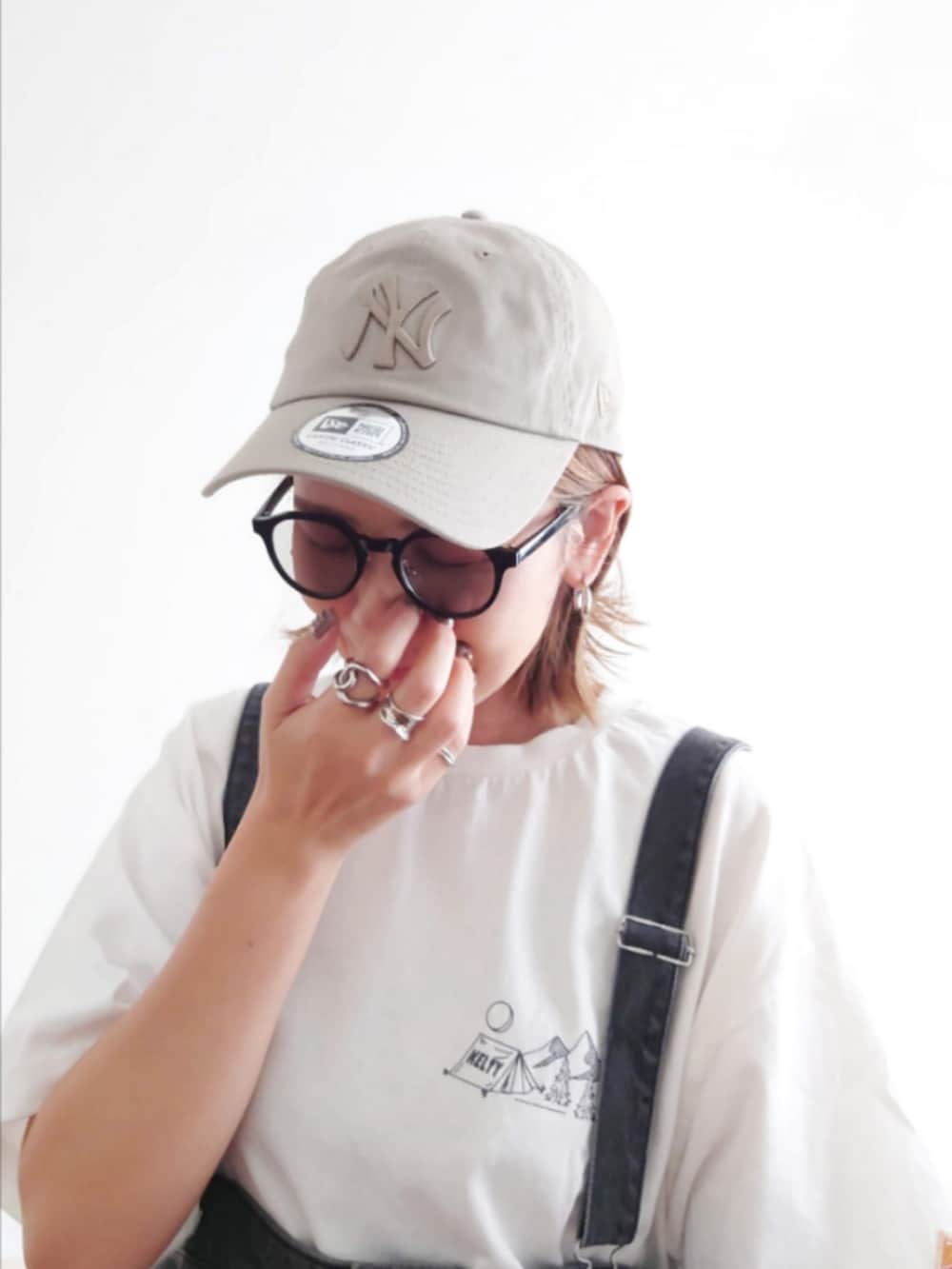 ブラック系のジャンパースカート、ホワイト系のTシャツ/カットソー、ブラック系のトートバッグを着用したレディースの秋コーディネートの5枚目の写真