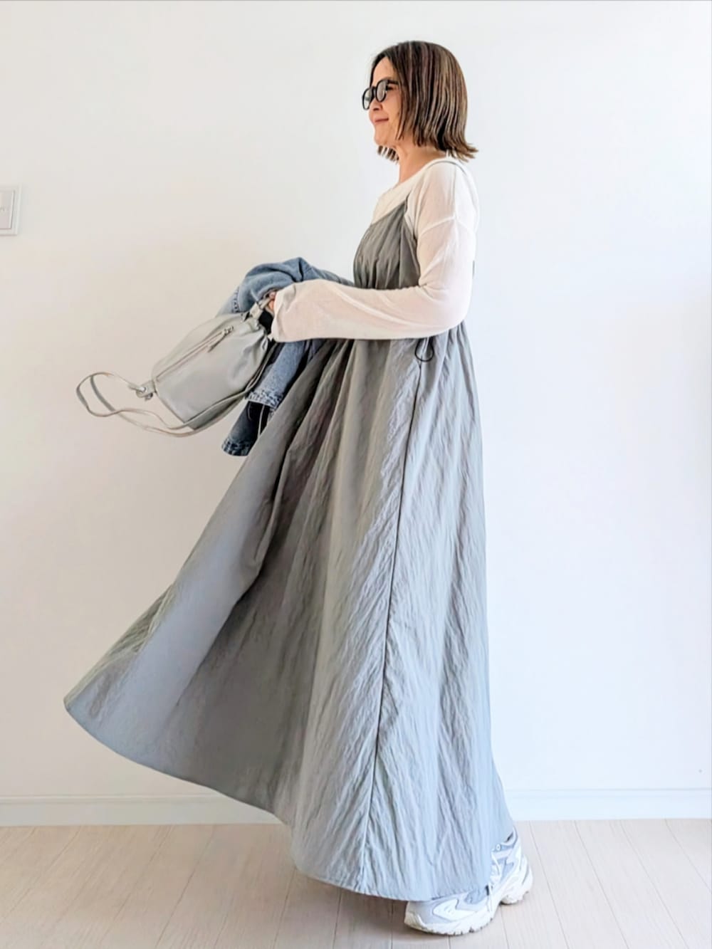 グレー系のワンピース、ホワイト系のTシャツ/カットソー、ブルー系のデニムジャケットを着用したレディースの春コーディネートの2枚目の写真