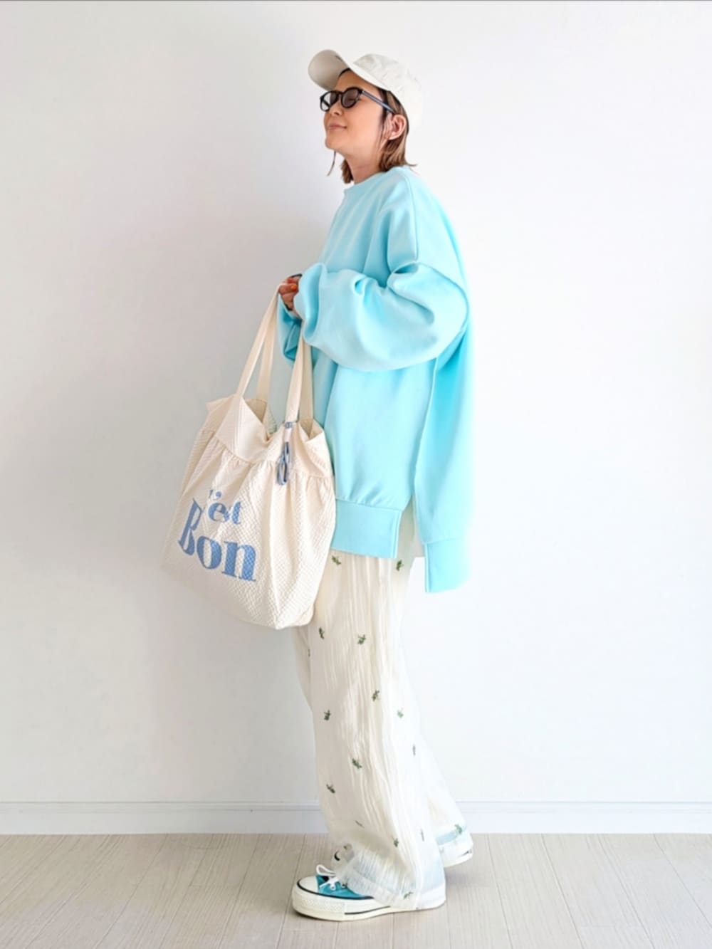 ホワイト系のその他パンツ、ホワイト系のトートバッグ、ブルー系のTシャツ/カットソーを着用したレディースの冬コーディネートの2枚目の写真