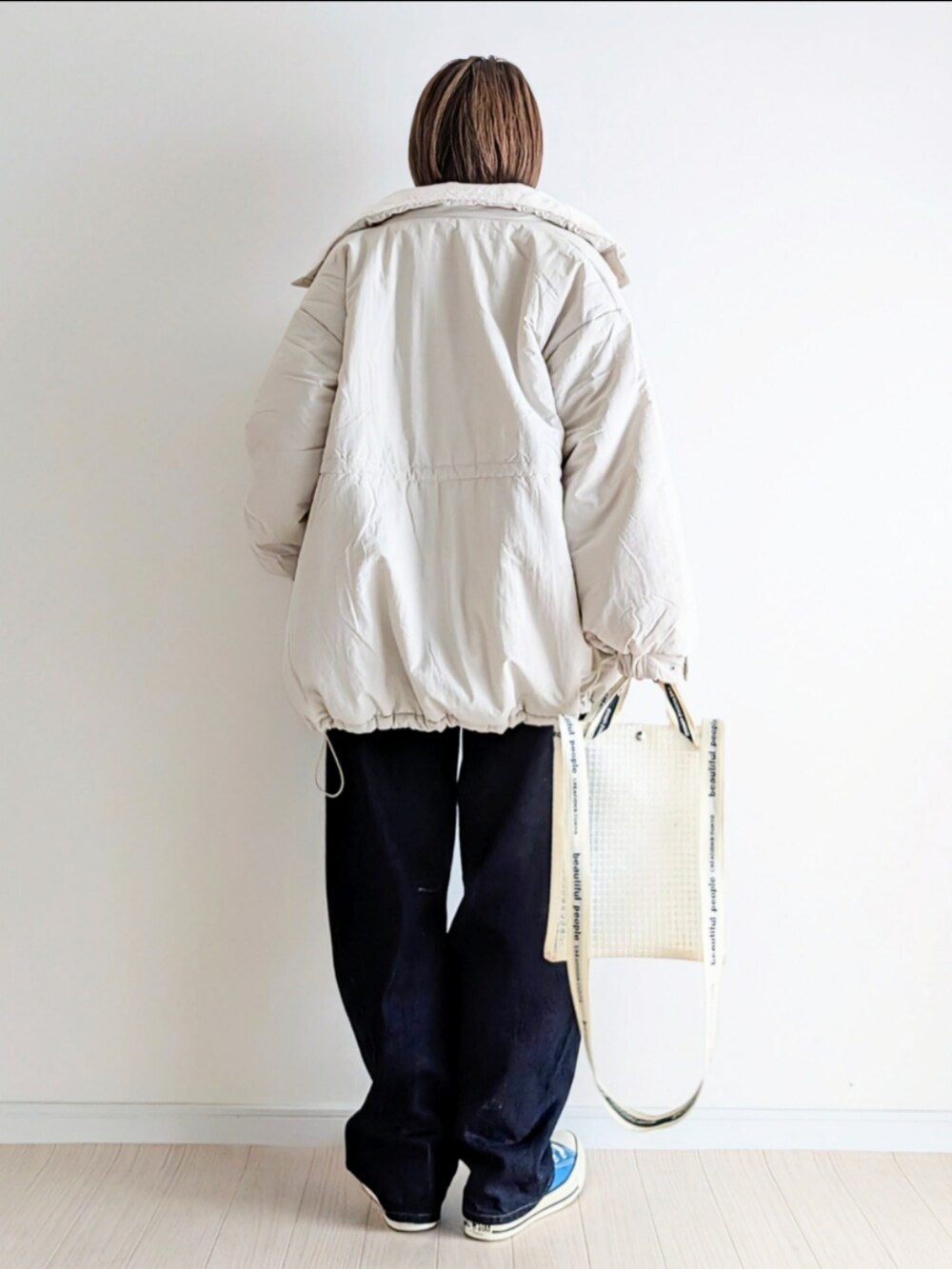 ホワイト系のブルゾン、ホワイト系のスウェット、ブルー系のデニムパンツを着用したレディースの冬コーディネートの4枚目の写真