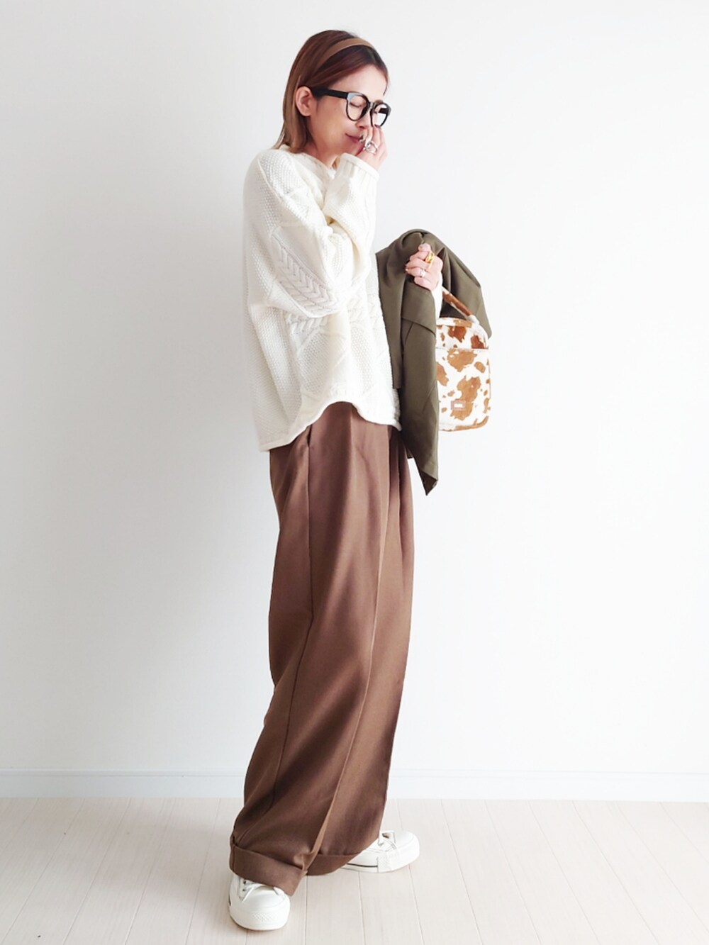 グリーン系のカバーオール、ホワイト系のニット/セーター、ブラウン系のパンツを着用したレディースの冬コーディネートの4枚目の写真