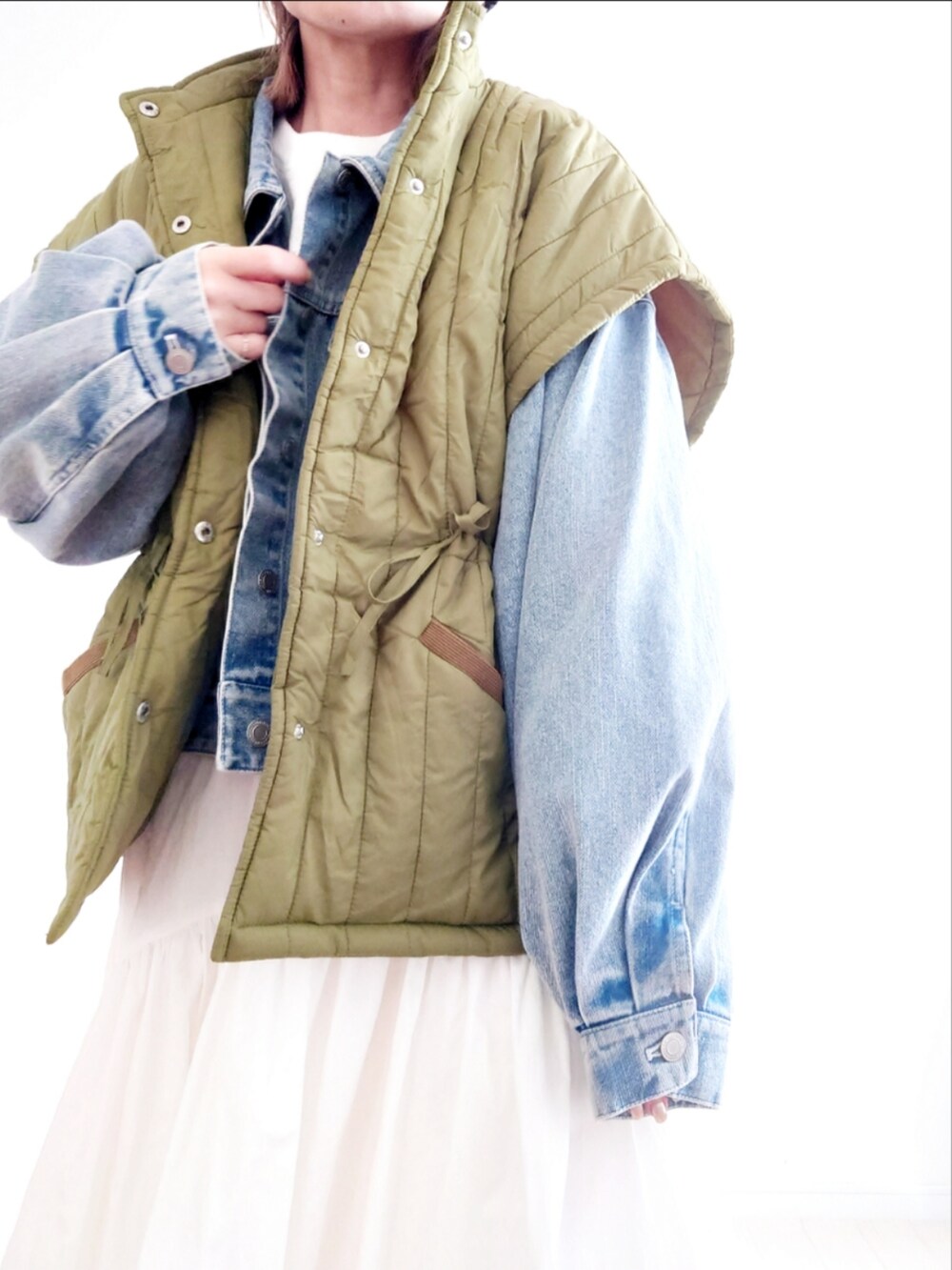 ブルー系のデニムジャケット、ホワイト系のスカート、ブラック系のブーツを着用したレディースの冬コーディネートの4枚目の写真