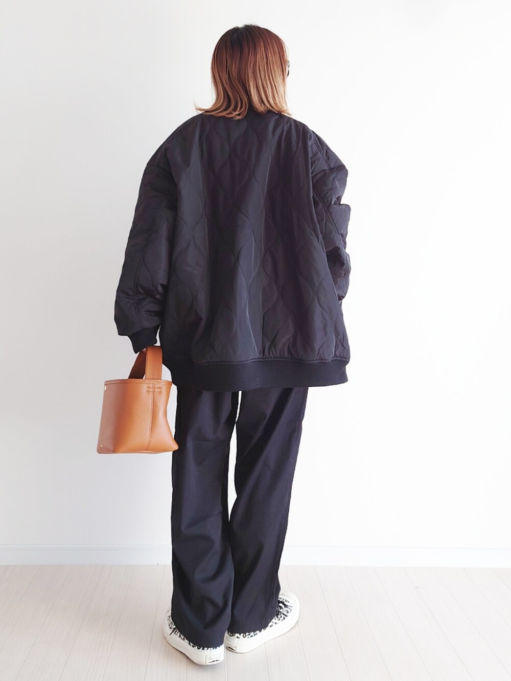 ブラック系のブルゾン、ブラック系のスラックス、グリーン系のニット/セーターを着用したレディースの冬コーディネートの4枚目の写真