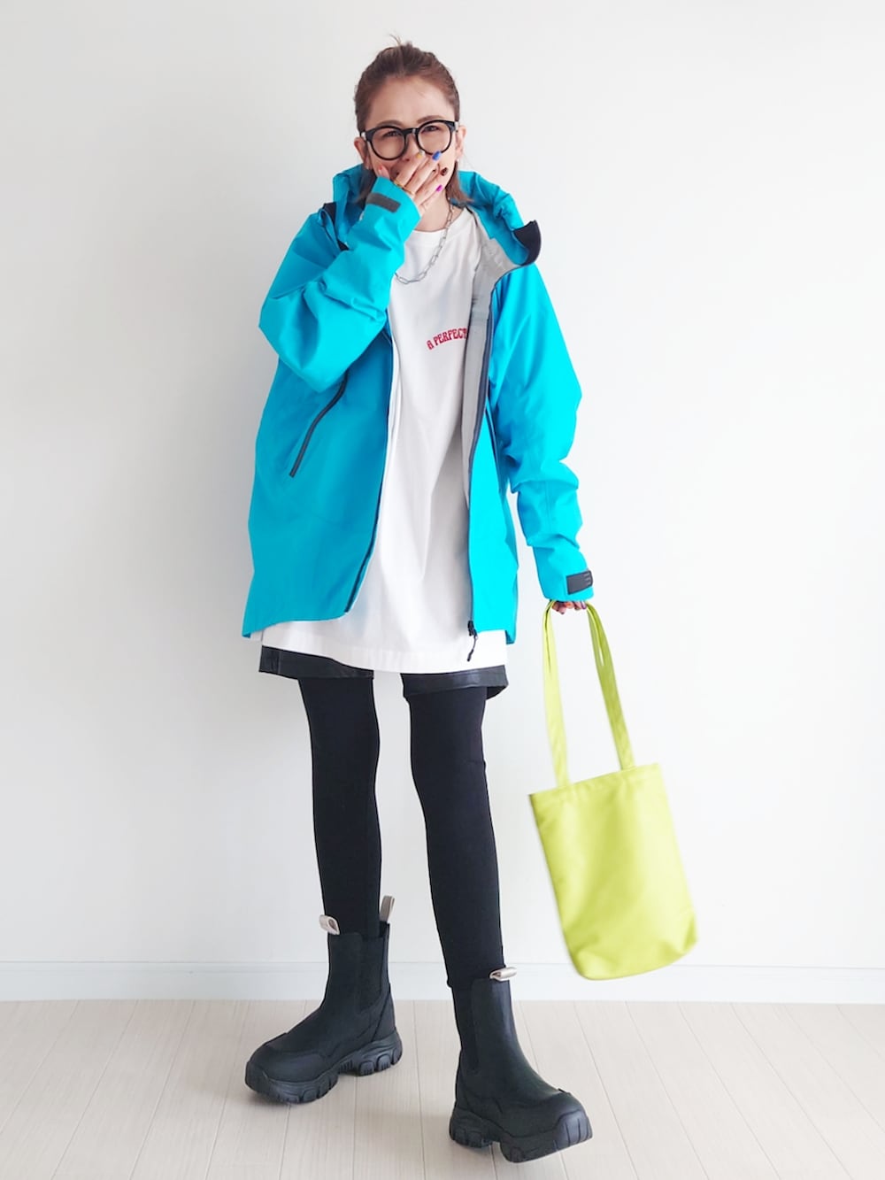 ブルー系のマウンテンパーカー、ホワイト系のTシャツ/カットソー、ブラック系のブーツを着用したレディースの秋コーディネートの3枚目の写真