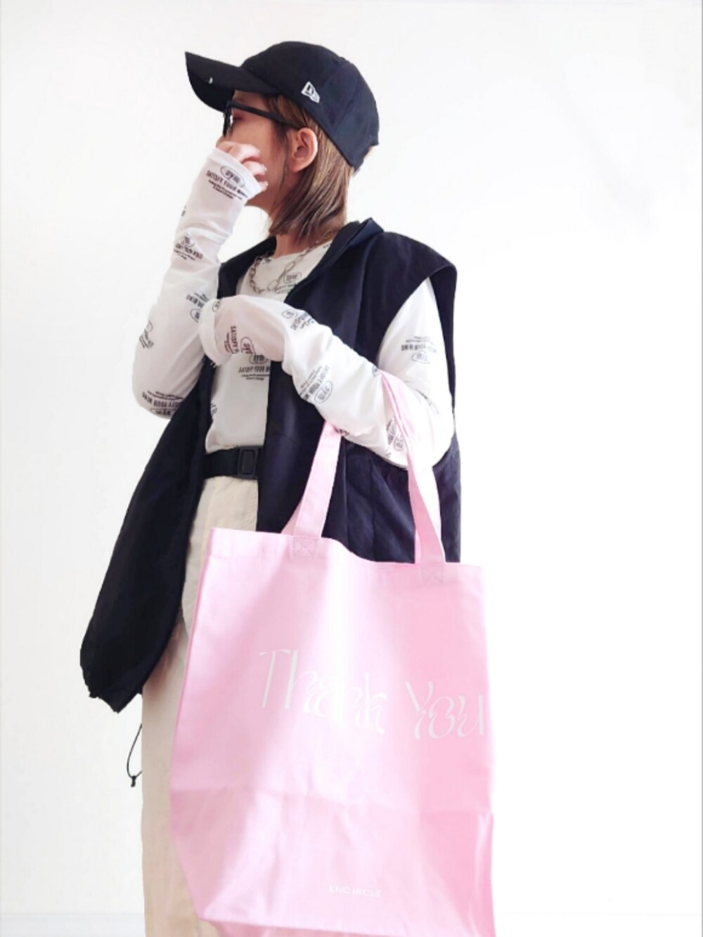ホワイト系のスカート、ピンク系のエコバッグ/サブバッグ、ホワイト系のTシャツ/カットソーを着用したレディースの春コーディネートの5枚目の写真