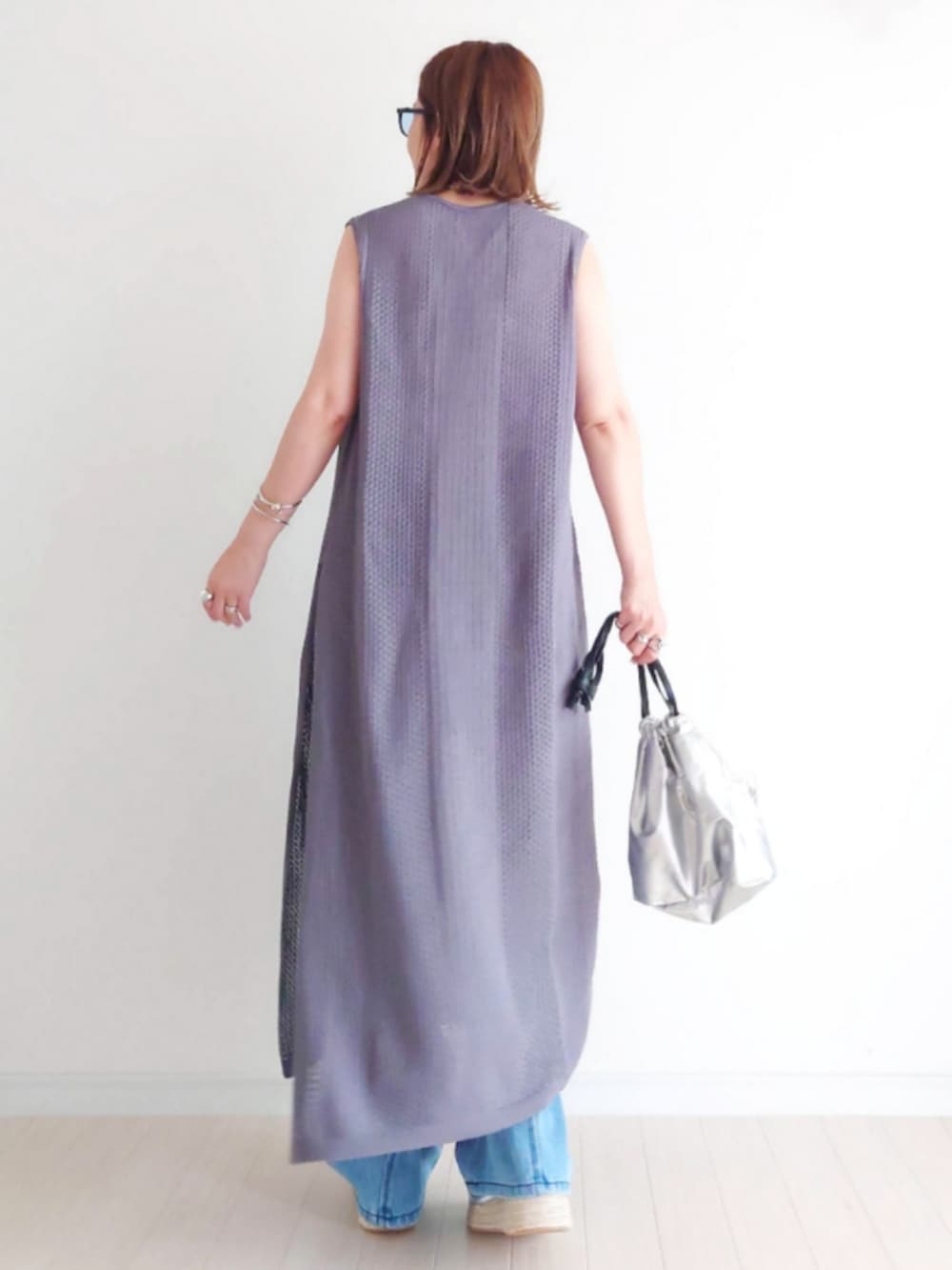 シルバー系のサンダル、ブルー系のデニムパンツ、グレー系のワンピースを着用したレディースの夏コーディネートの4枚目の写真