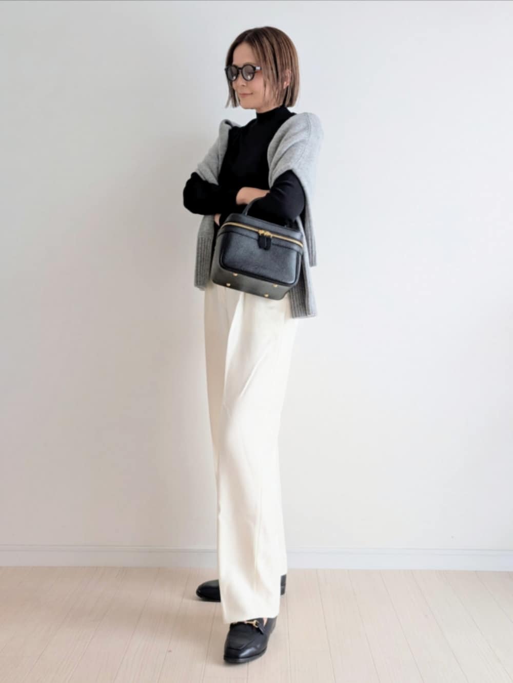 ブラック系のハンドバッグ、ブラック系のニット/セーター、グレー系のニット/セーターを着用したレディースの秋コーディネートの4枚目の写真