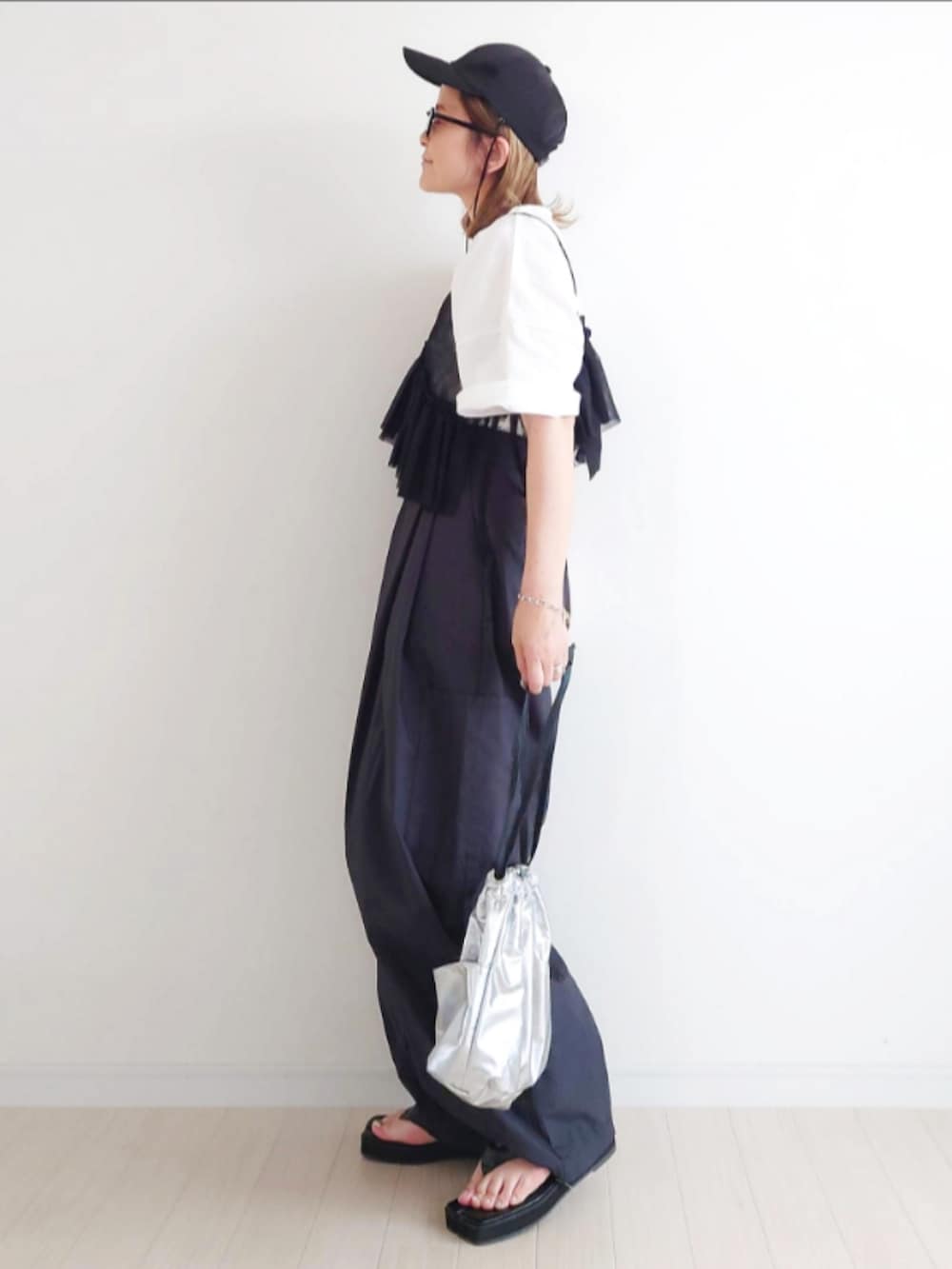 ブラック系のカーゴパンツ、ブラック系のキャミソール、ホワイト系のTシャツ/カットソーを着用したレディースの春コーディネートの2枚目の写真