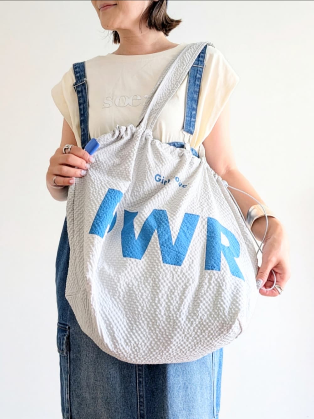 ブルー系のジャンパースカート、ホワイト系のTシャツ/カットソー、シルバー系のサンダルを着用したレディースの夏コーディネートの5枚目の写真