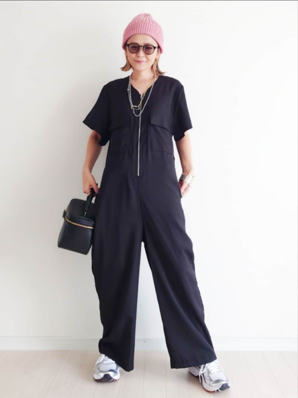 ブラック系のつなぎ/オールインワン、ホワイト系のスニーカー、ピンク系のニットキャップ/ビーニーを着用したレディースの夏コーディネートの2枚目の写真