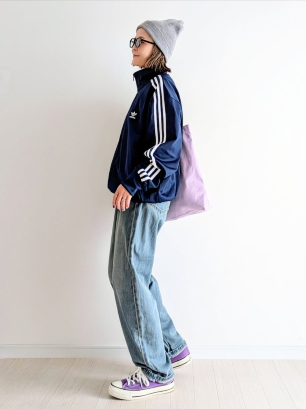 ブルー系のデニムパンツ、ブルー系のジャージ、パープル系のトートバッグを着用したレディースの秋コーディネートの3枚目の写真