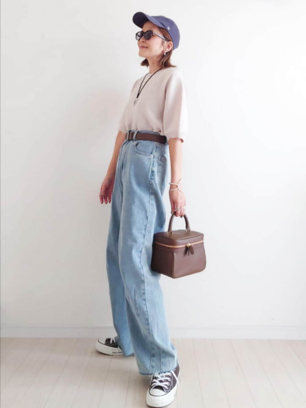 ホワイト系のニット/セーター、ブルー系のデニムパンツ、ブラウン系のハンドバッグを着用したレディースの秋コーディネートの2枚目の写真