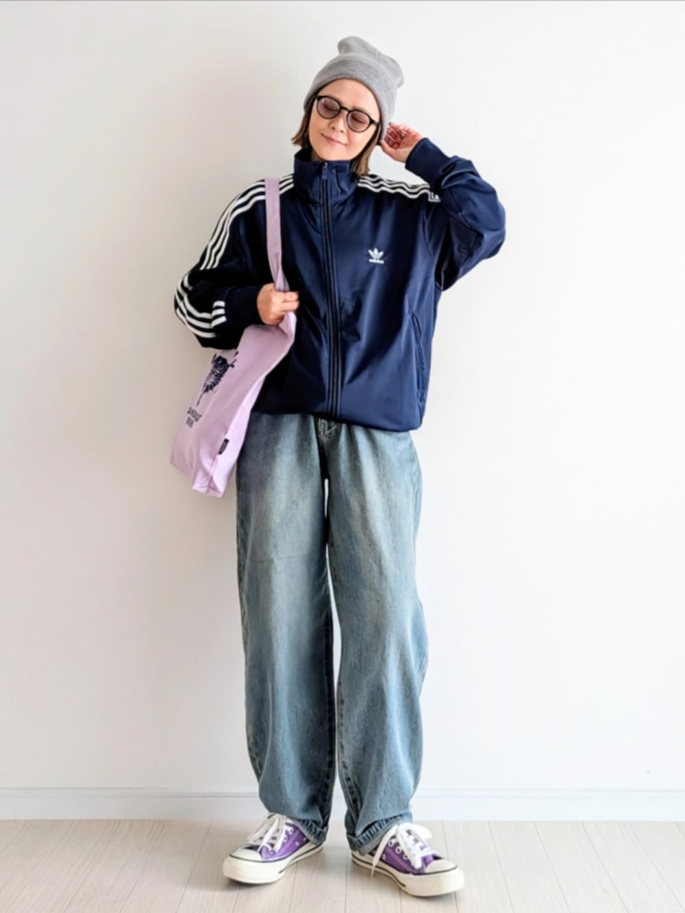 ブルー系のデニムパンツ、ブルー系のジャージ、パープル系のトートバッグを着用したレディースの秋コーディネートの5枚目の写真