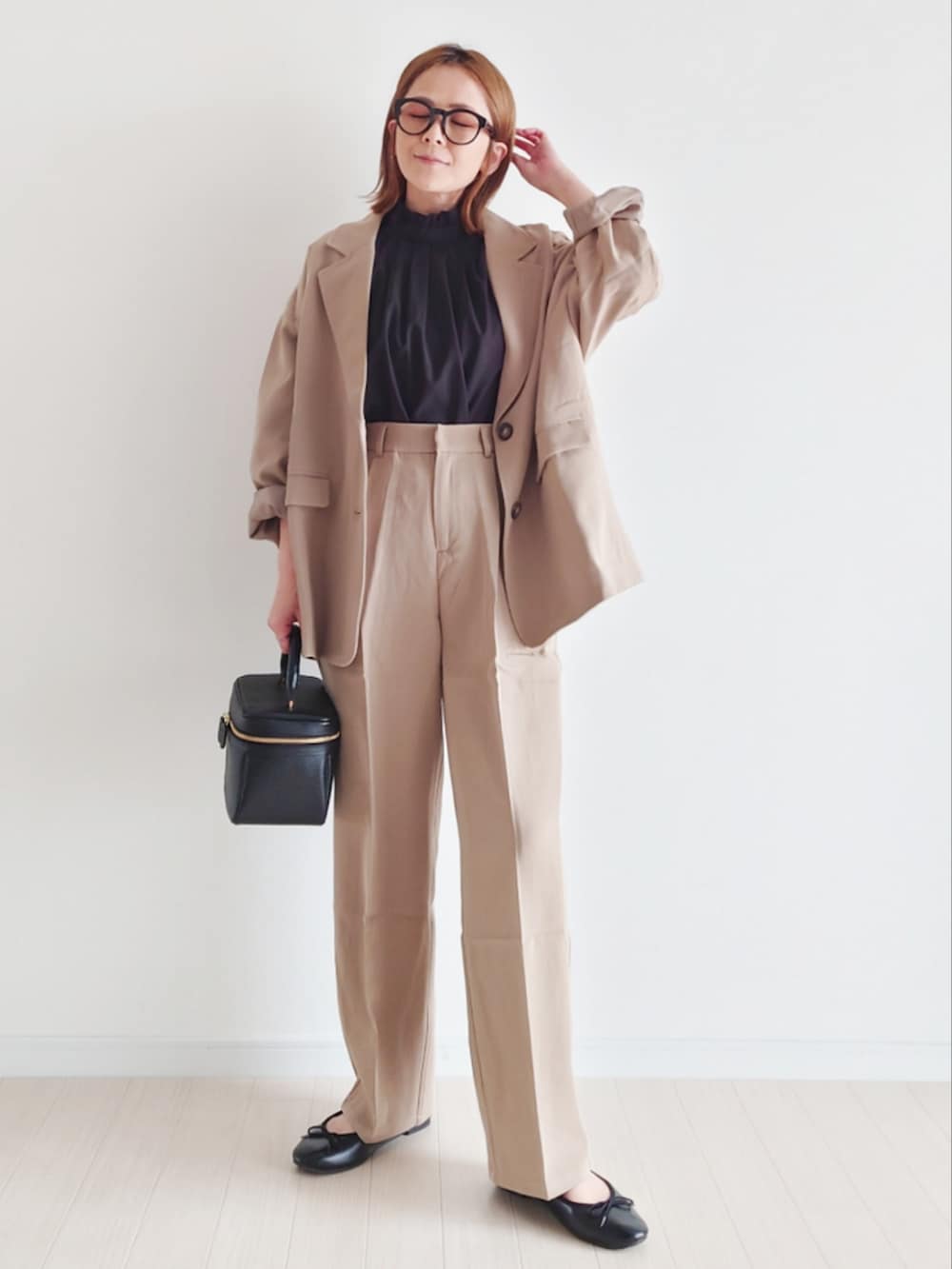 ベージュ系のセットアップ、ブラック系のシャツ/ブラウス、ブラック系のハンドバッグを着用したレディースの冬コーディネートの5枚目の写真