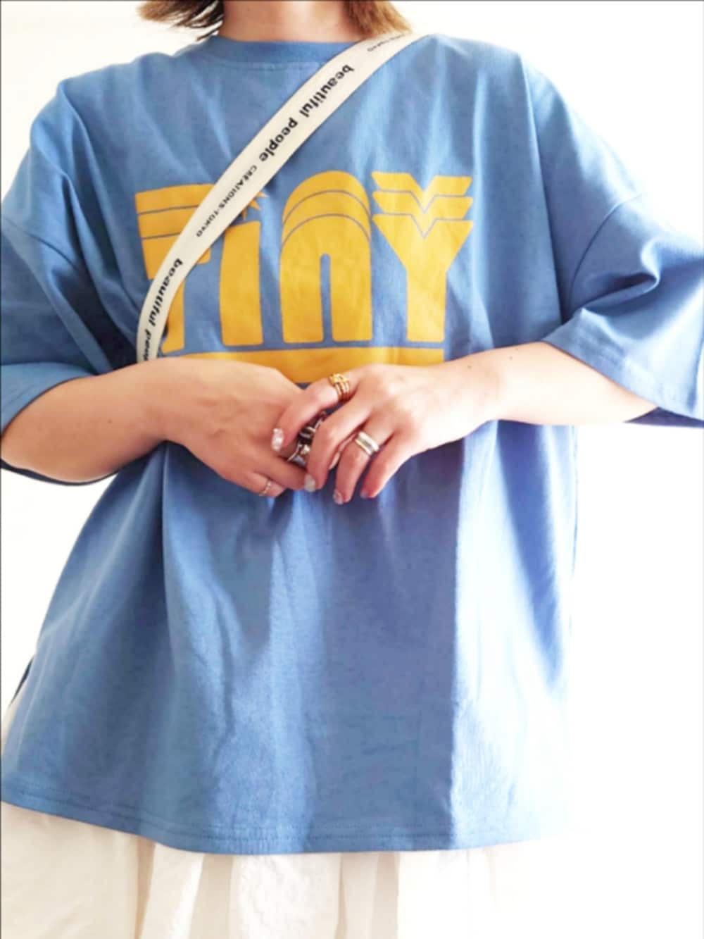 ブルー系のTシャツ/カットソー、ホワイト系のスカート、その他のスニーカーを着用したレディースの春コーディネートの4枚目の写真