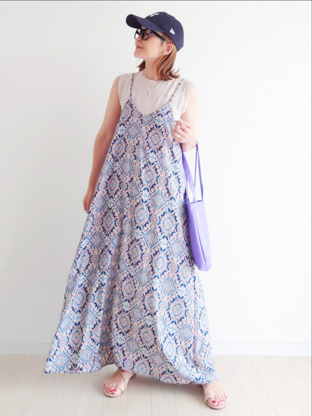 ブルー系のワンピース、パープル系のトートバッグ、ベージュ系のタンクトップを着用したレディースの夏コーディネートの3枚目の写真