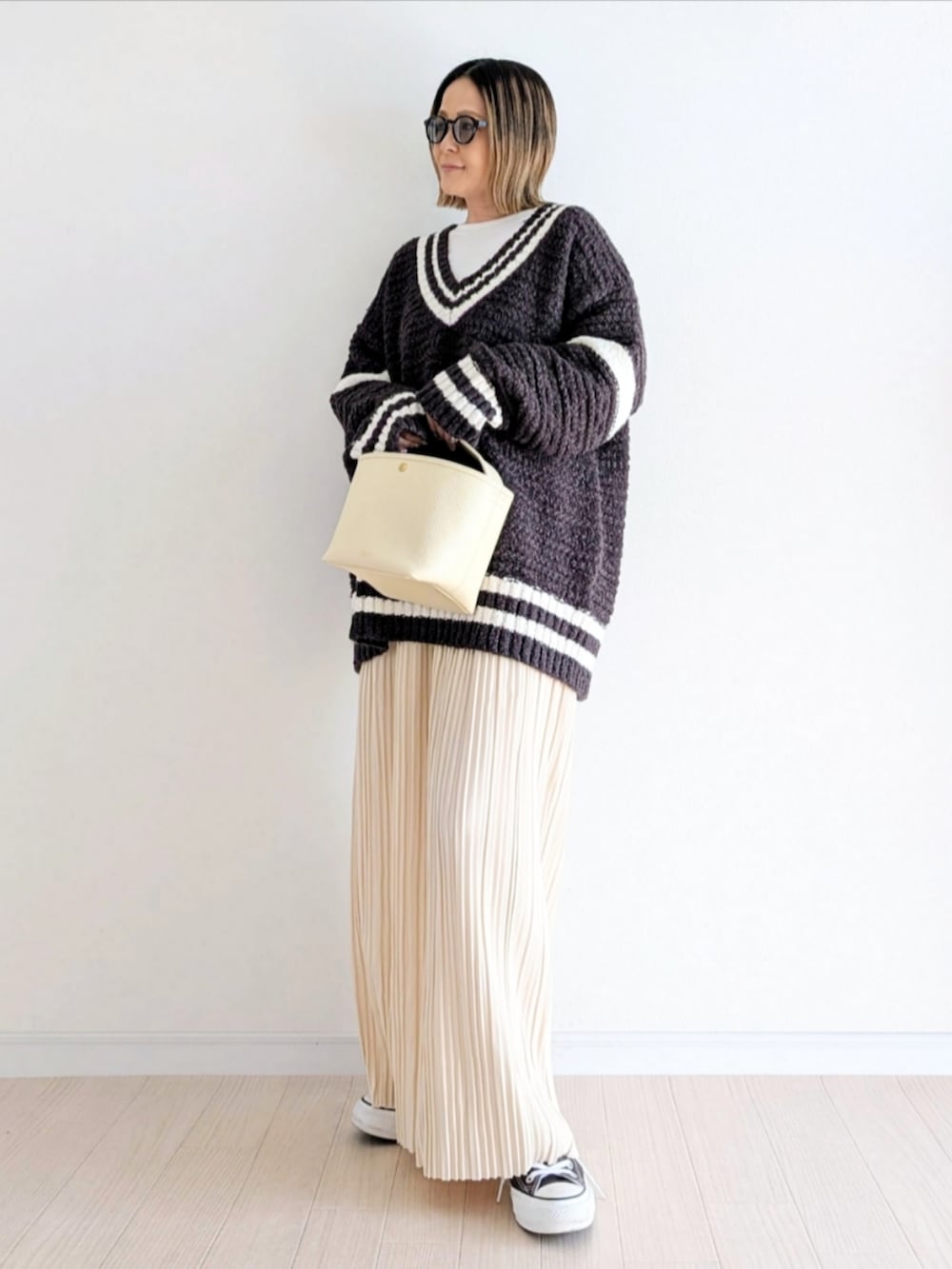 ホワイト系のスカート、グレー系のニット/セーター、その他のシューズを着用したレディースの冬コーディネートの2枚目の写真