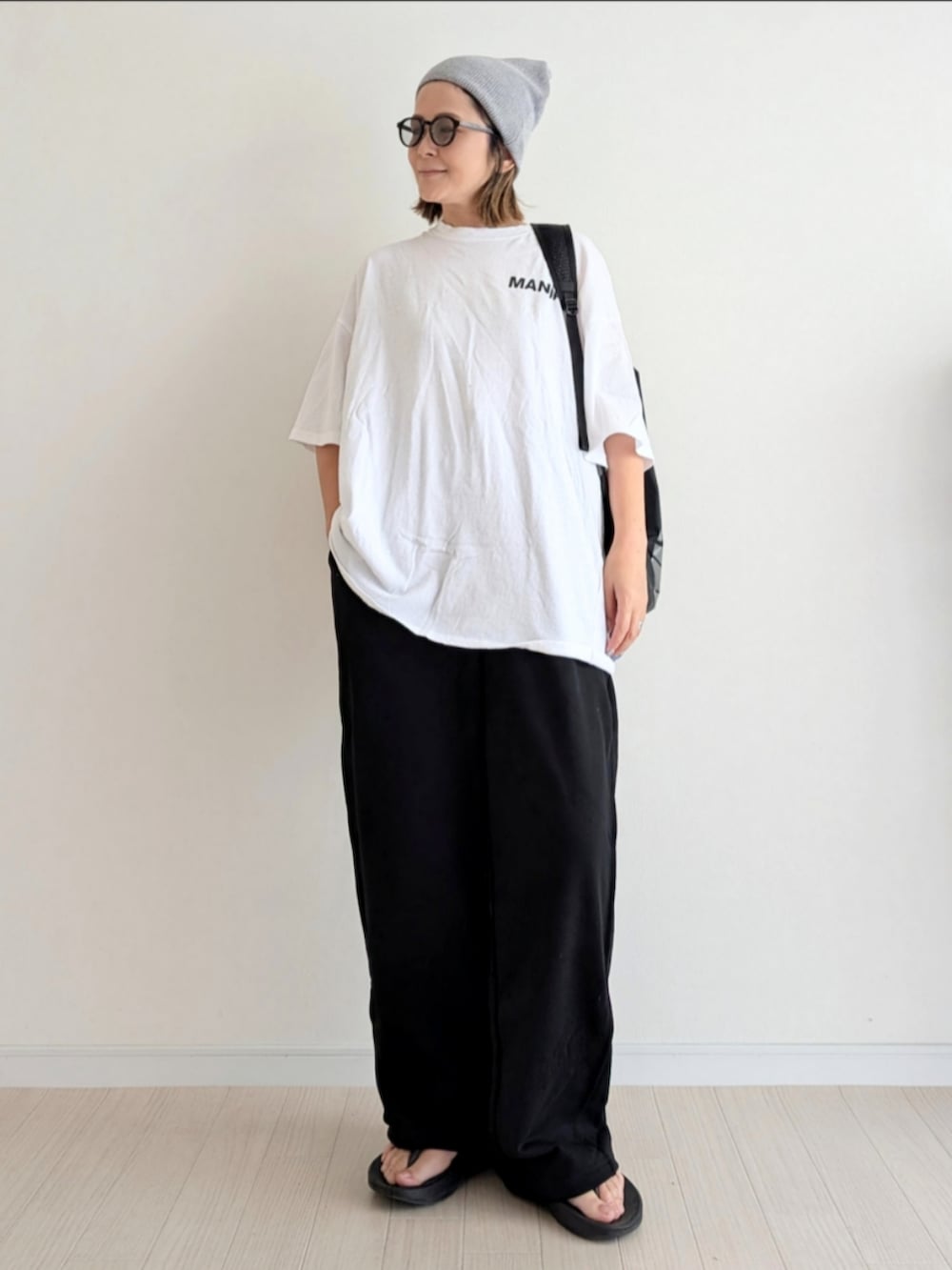 ブラック系のその他パンツ、ホワイト系のTシャツ/カットソー、ブラック系のサンダルを着用したレディースの夏コーディネートの2枚目の写真