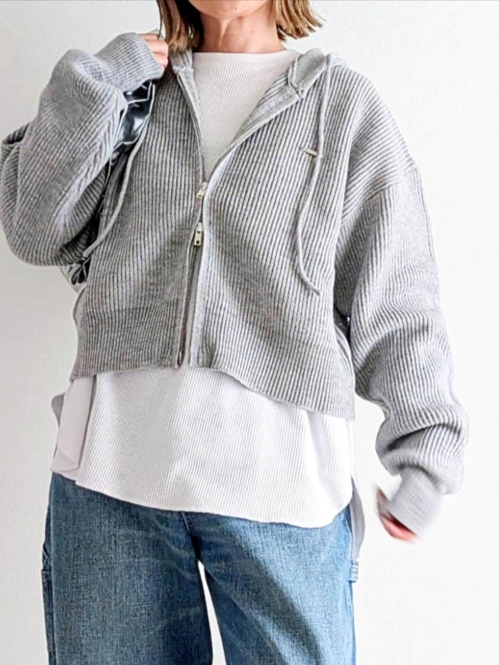 ブルー系のデニムパンツ、グレー系のパーカー、ピンク系のスニーカーを着用したレディースの冬コーディネートの5枚目の写真