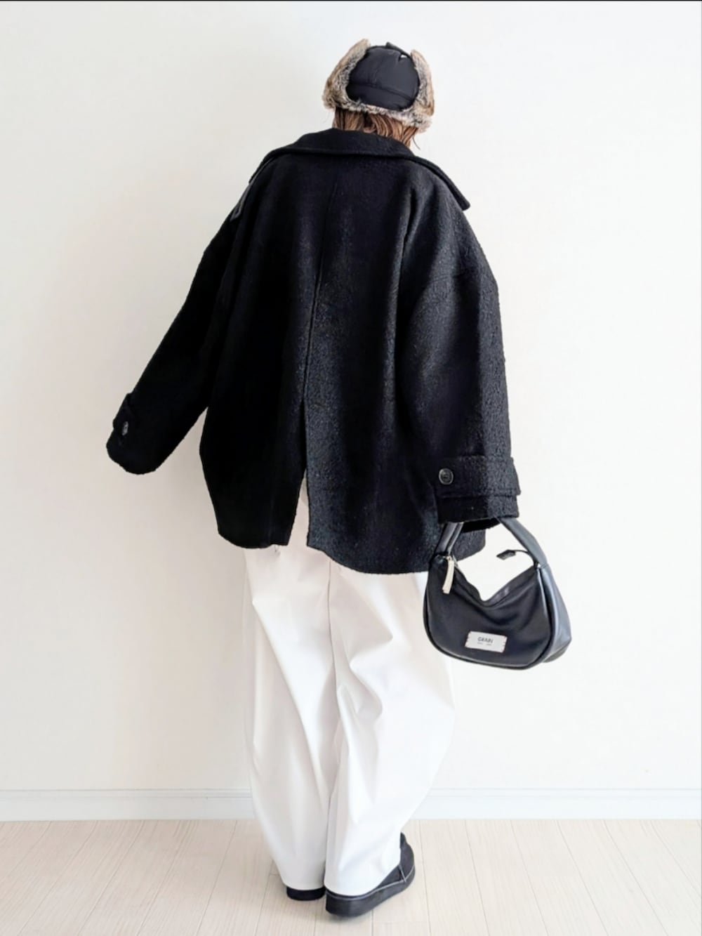 ブラック系のピーコート、レッド系のニット/セーターを着用したレディースの冬コーディネートの5枚目の写真