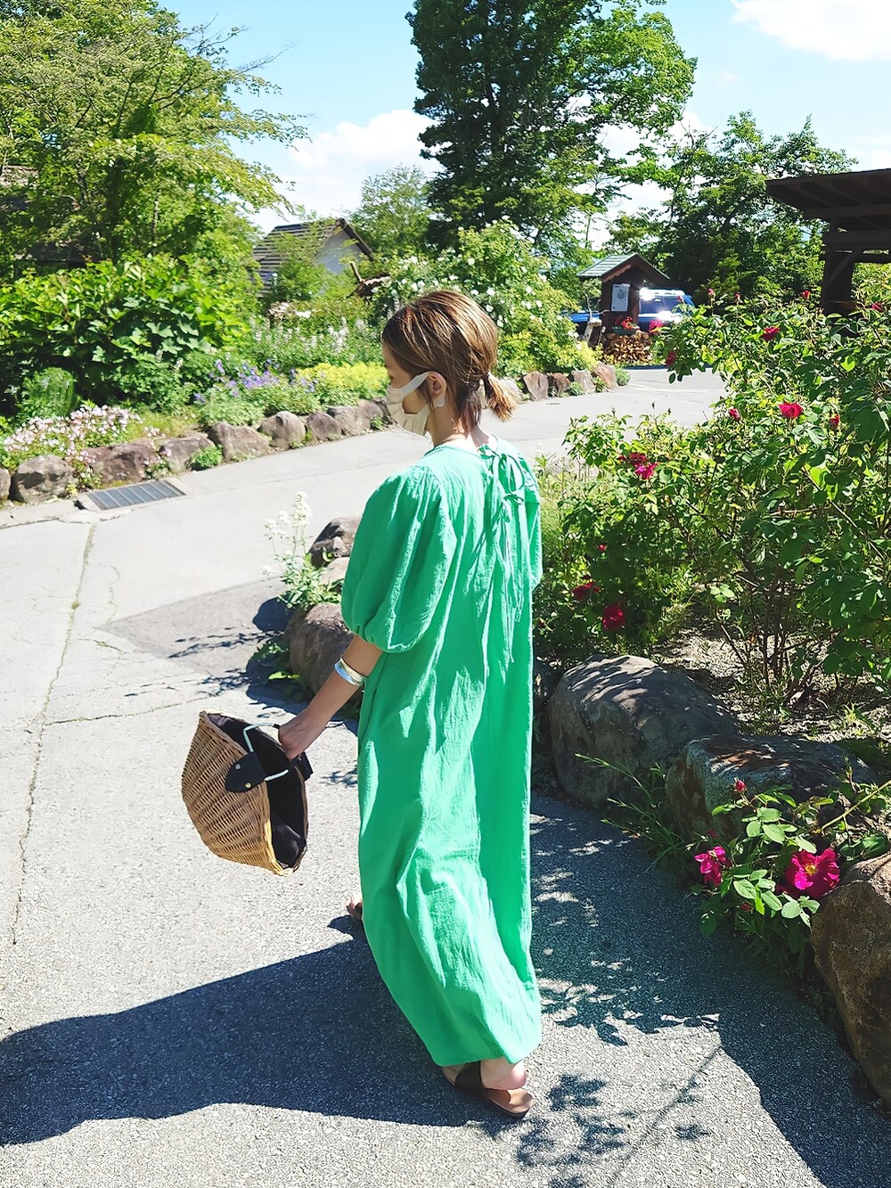 グリーン系のワンピース、ブラウン系のかごバッグ、ブラウン系のサンダルを着用したレディースの夏コーディネートの3枚目の写真