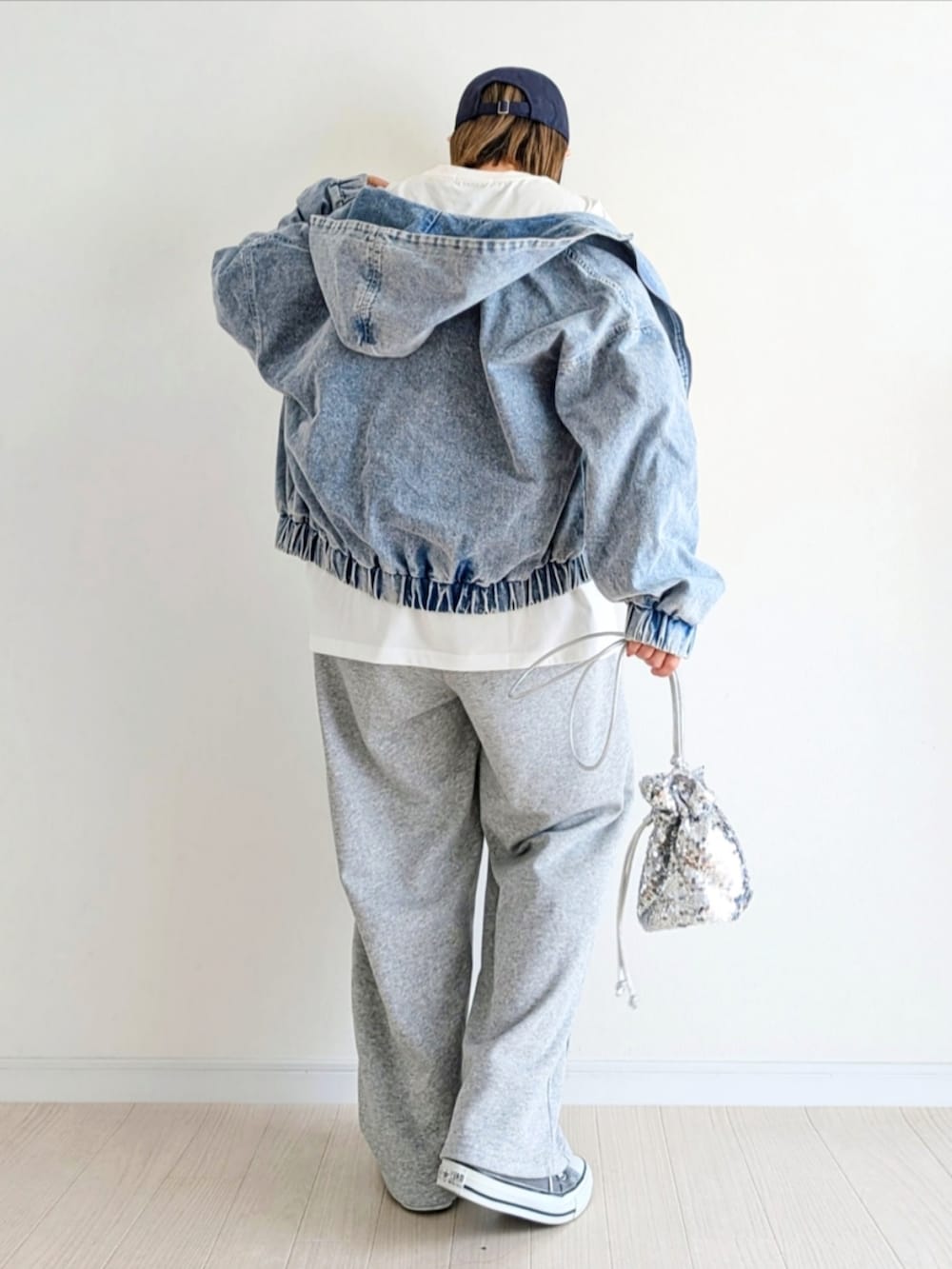 ブルー系のデニムジャケット、ホワイト系のTシャツ/カットソー、グレー系のスウェットパンツを着用したレディースの春コーディネートの3枚目の写真