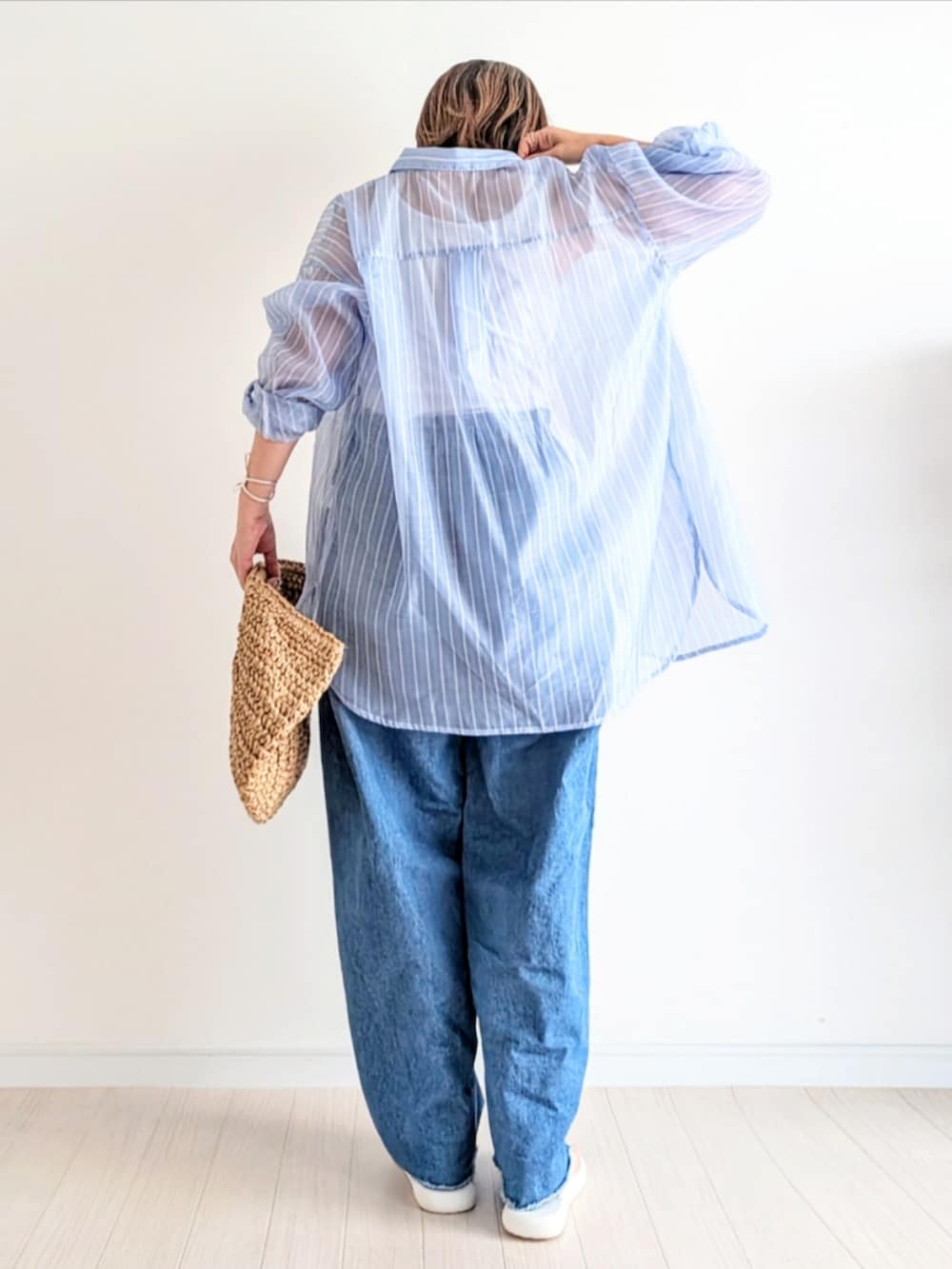 ホワイト系のサンダル、イエロー系のかごバッグ、ブルー系のシャツ/ブラウスを着用したレディースの春コーディネートの3枚目の写真