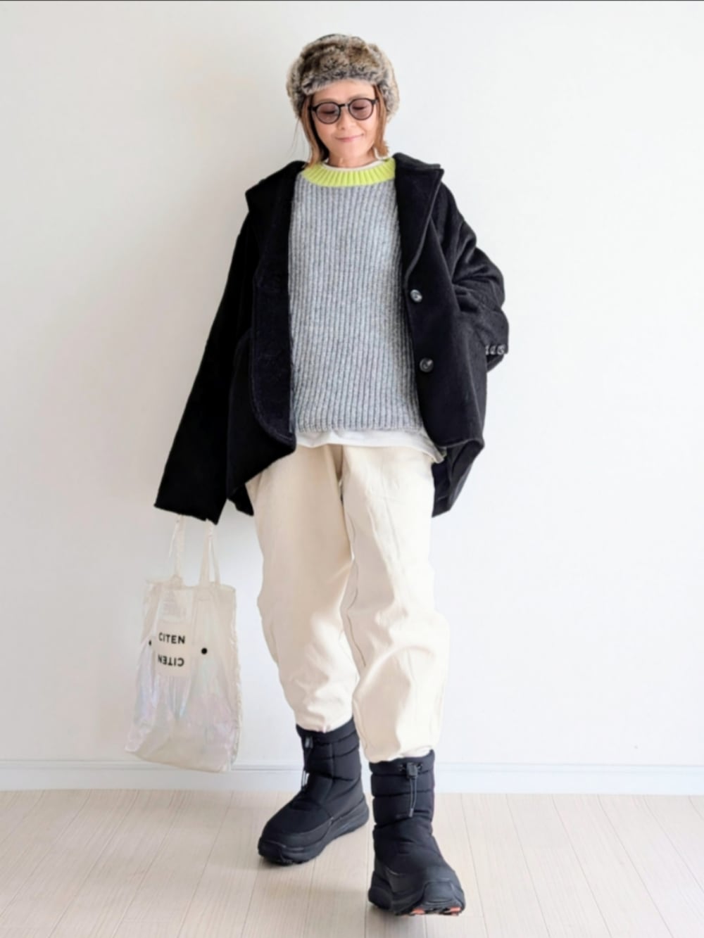 グレー系のニット/セーター、ブラック系のテーラードジャケット、ブラック系のブーツを着用したレディースの冬コーディネートの5枚目の写真