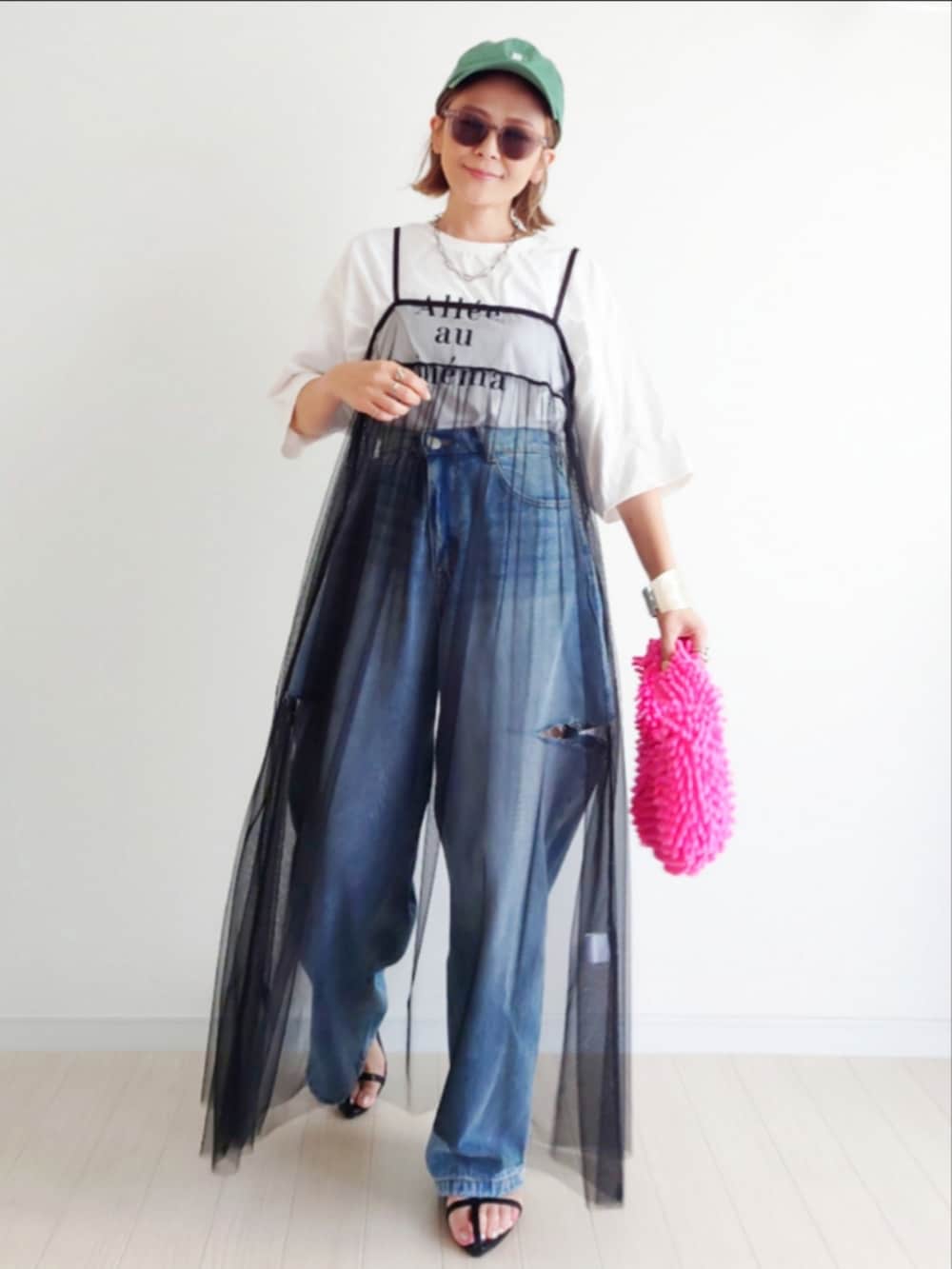 ブラック系のワンピース、ピンク系のトートバッグ、ブルー系のデニムパンツを着用したレディースの夏コーディネートの2枚目の写真