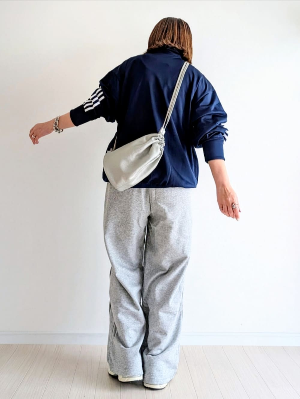 ブルー系のジャージ、グレー系のスウェットパンツ、シルバー系のショルダーバッグを着用したレディースの春コーディネートの4枚目の写真