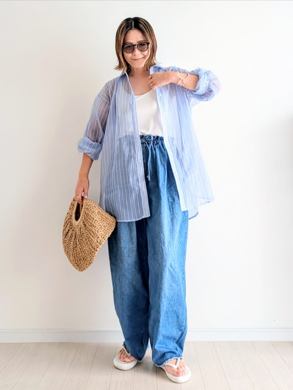 ホワイト系のサンダル、イエロー系のかごバッグ、ブルー系のシャツ/ブラウスを着用したレディースの春コーディネートの4枚目の写真