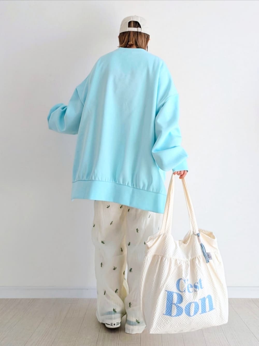 ホワイト系のその他パンツ、ホワイト系のトートバッグ、ブルー系のTシャツ/カットソーを着用したレディースの冬コーディネートの3枚目の写真