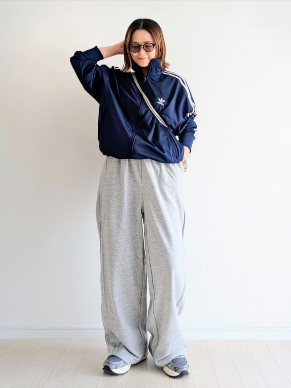 ブルー系のジャージ、グレー系のスウェットパンツ、シルバー系のショルダーバッグを着用したレディースの春コーディネートの3枚目の写真