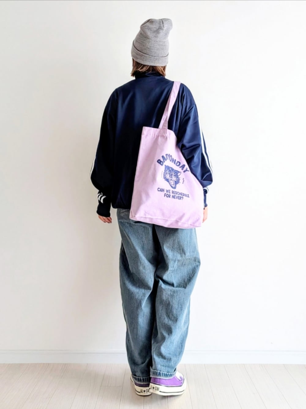 ブルー系のデニムパンツ、ブルー系のジャージ、パープル系のトートバッグを着用したレディースの秋コーディネートの4枚目の写真