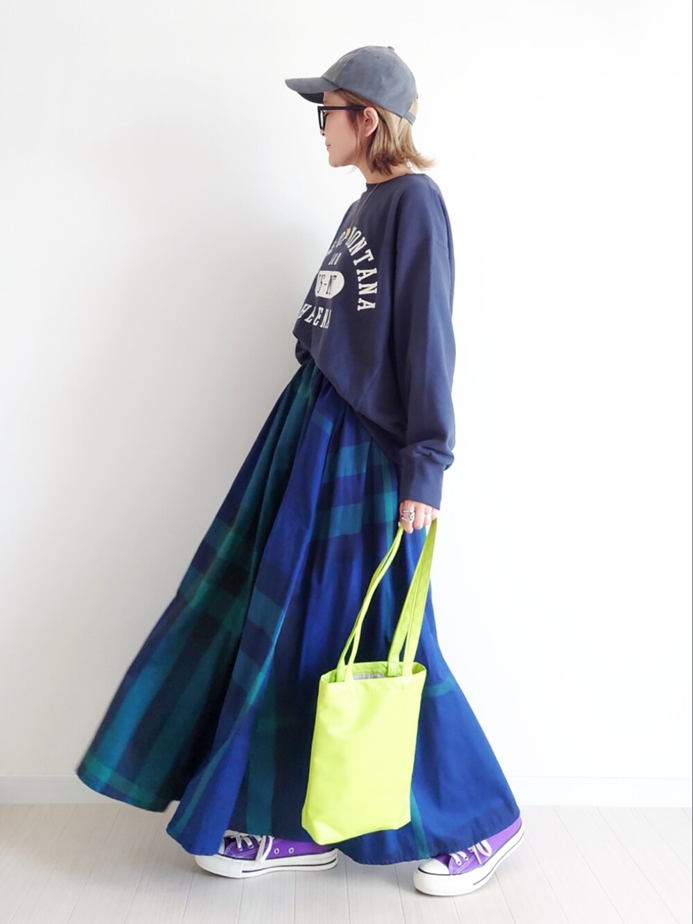 ブラック系のスウェット、ブルー系のスカート、パープル系のスニーカーを着用したレディースの秋コーディネートの3枚目の写真