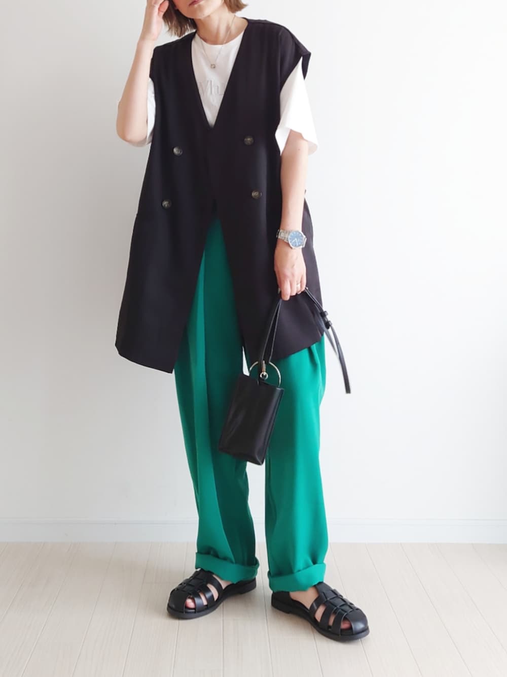 ホワイト系のTシャツ/カットソー、グリーン系のその他パンツ、ブラック系のベストを着用したレディースの春コーディネートの3枚目の写真
