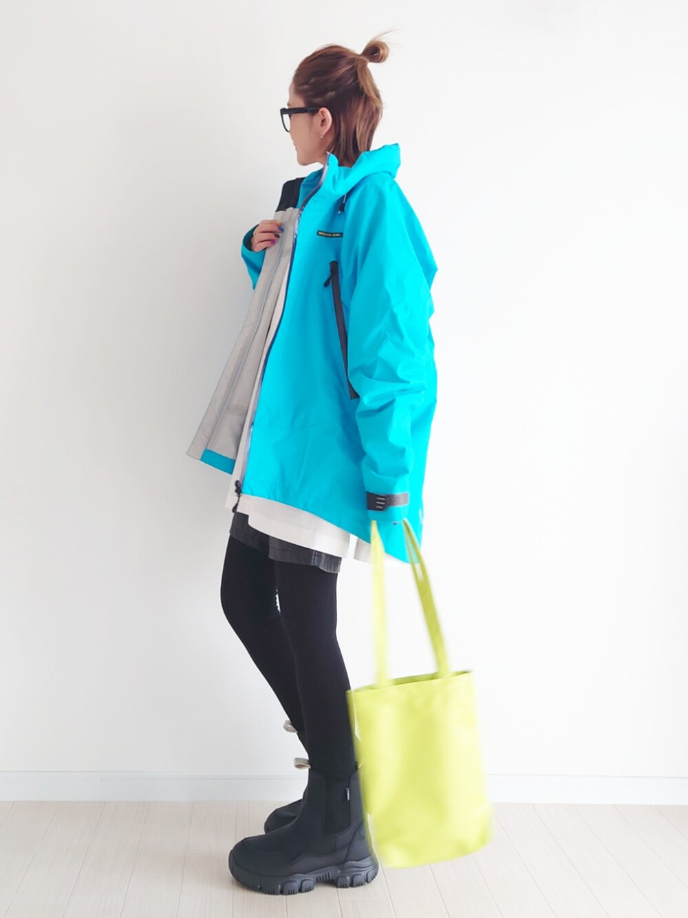 ブルー系のマウンテンパーカー、ホワイト系のTシャツ/カットソー、ブラック系のブーツを着用したレディースの秋コーディネートの4枚目の写真