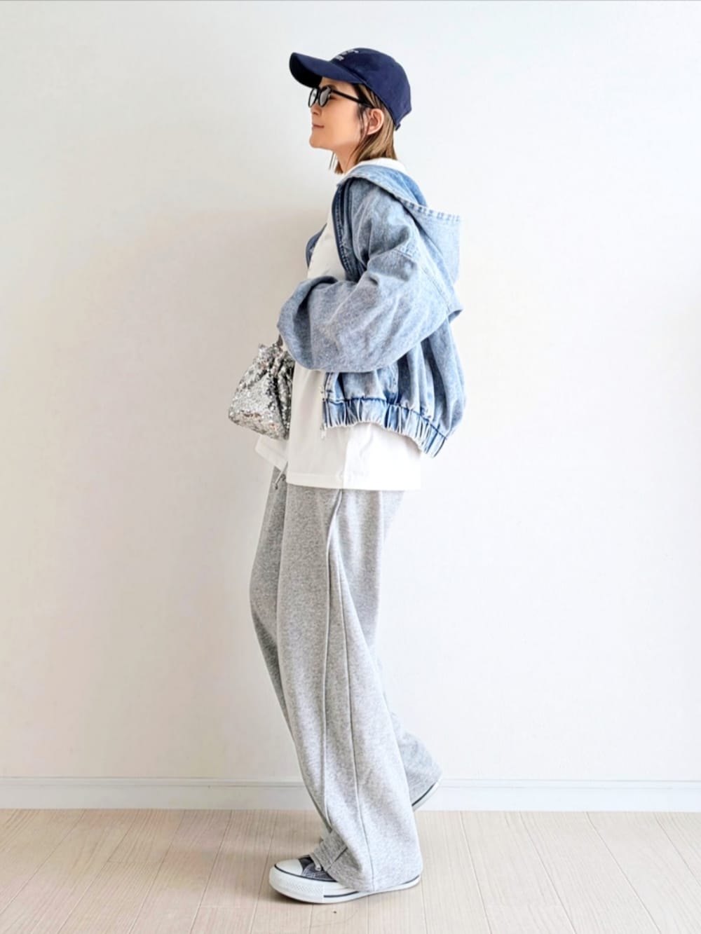 ブルー系のデニムジャケット、ホワイト系のTシャツ/カットソー、グレー系のスウェットパンツを着用したレディースの春コーディネートの2枚目の写真