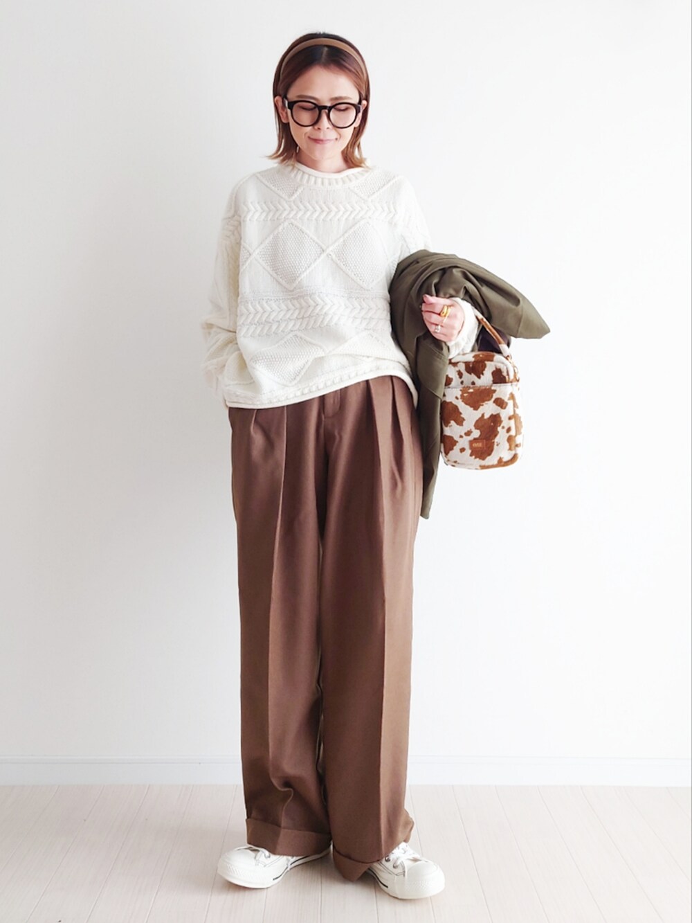 グリーン系のカバーオール、ホワイト系のニット/セーター、ブラウン系のパンツを着用したレディースの冬コーディネートの5枚目の写真