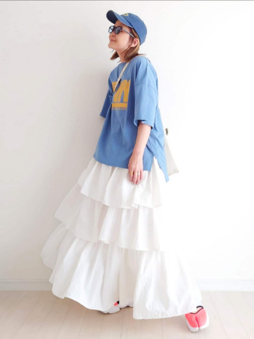 ブルー系のTシャツ/カットソー、ホワイト系のスカート、その他のスニーカーを着用したレディースの春コーディネートの2枚目の写真