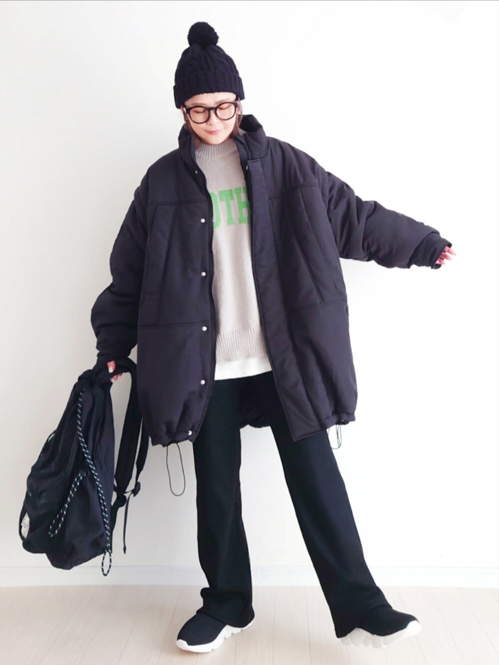 ブラック系のその他アウター、ブラック系のその他パンツ、グレー系のニット/セーターを着用したレディースの冬コーディネートの2枚目の写真