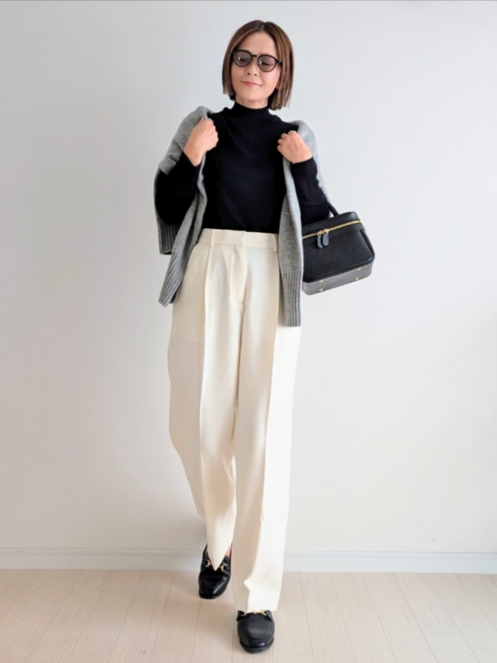 ブラック系のハンドバッグ、ブラック系のニット/セーター、グレー系のニット/セーターを着用したレディースの秋コーディネートの2枚目の写真