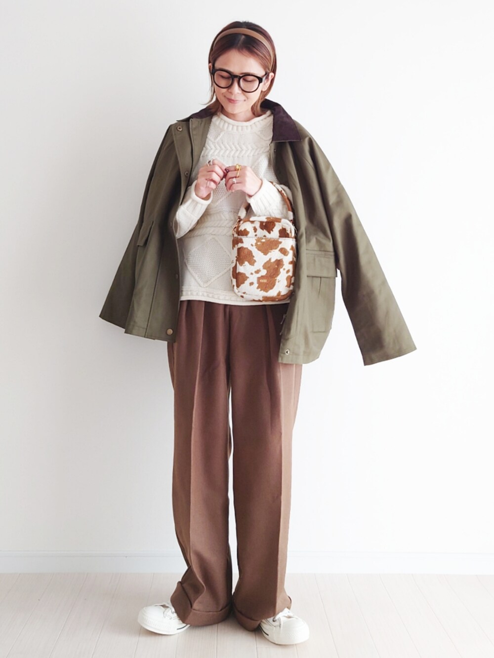 グリーン系のカバーオール、ホワイト系のニット/セーター、ブラウン系のパンツを着用したレディースの冬コーディネートの3枚目の写真