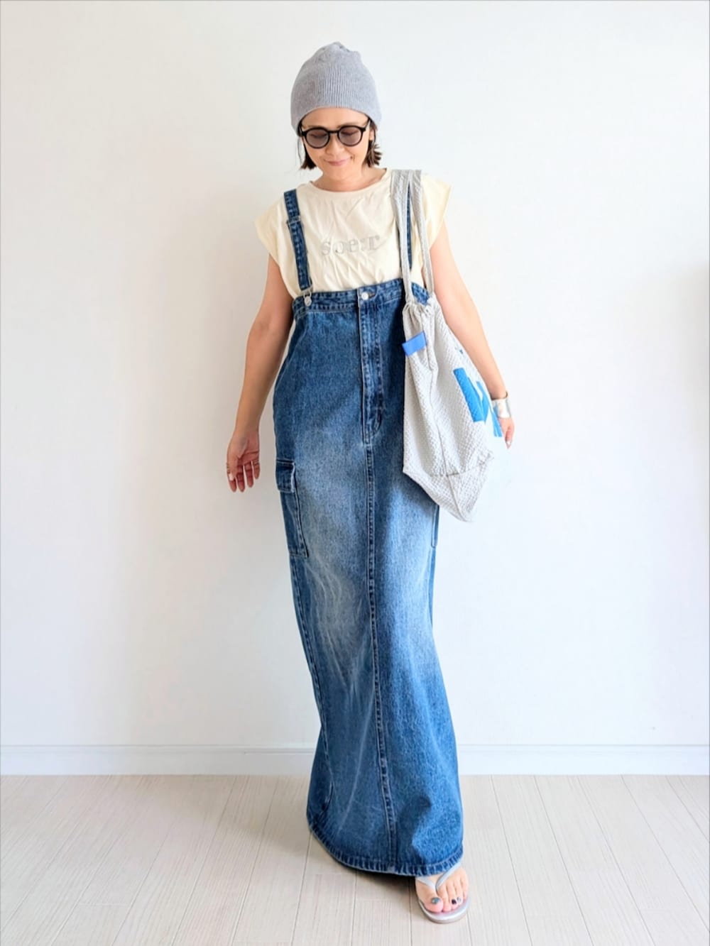 ブルー系のジャンパースカート、ホワイト系のTシャツ/カットソー、シルバー系のサンダルを着用したレディースの夏コーディネートの4枚目の写真